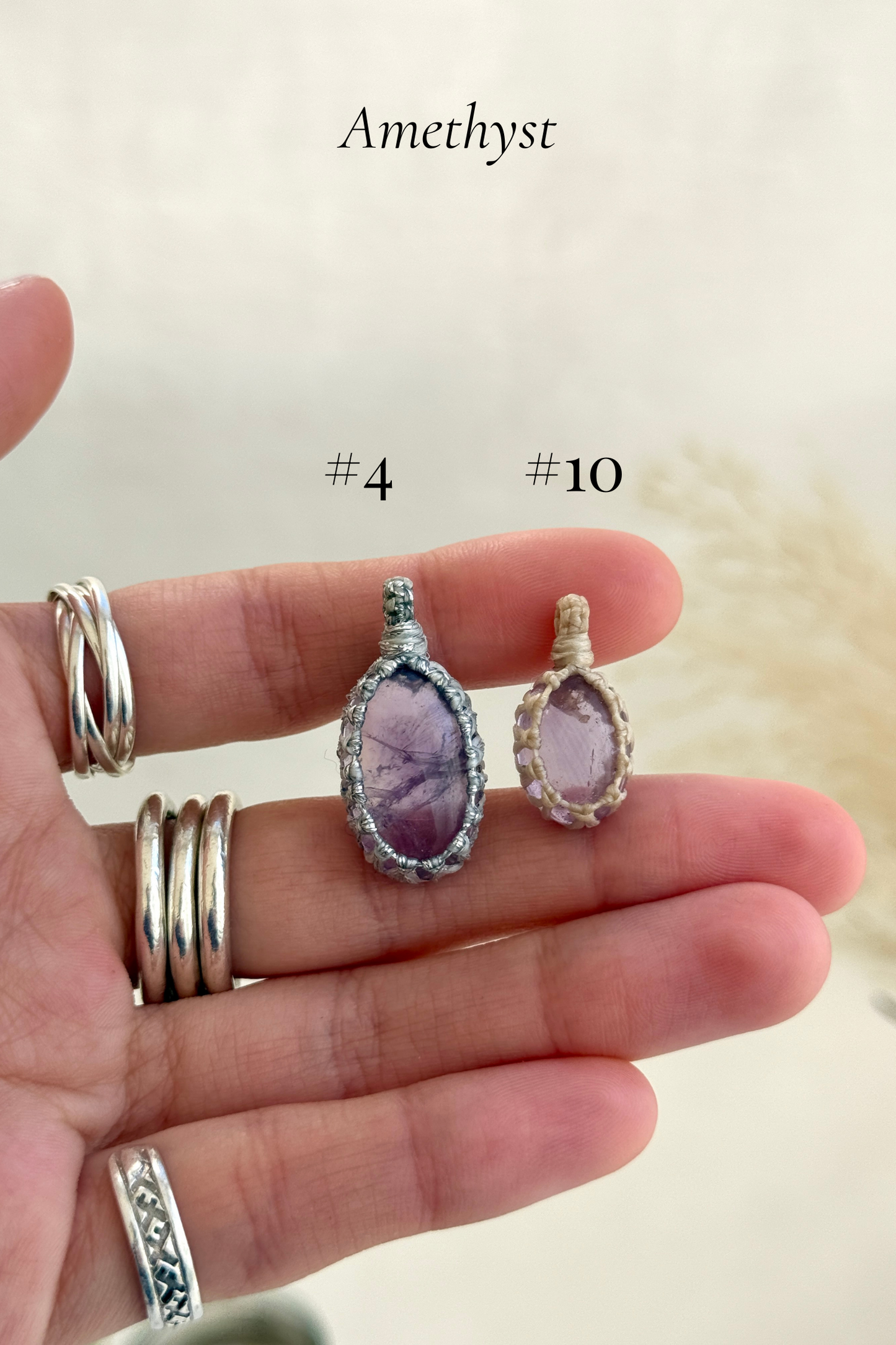 Close-up of Candy Charms featuring Amethyst pendants held in hand, showing the size of the charm and detailed gemstone features.