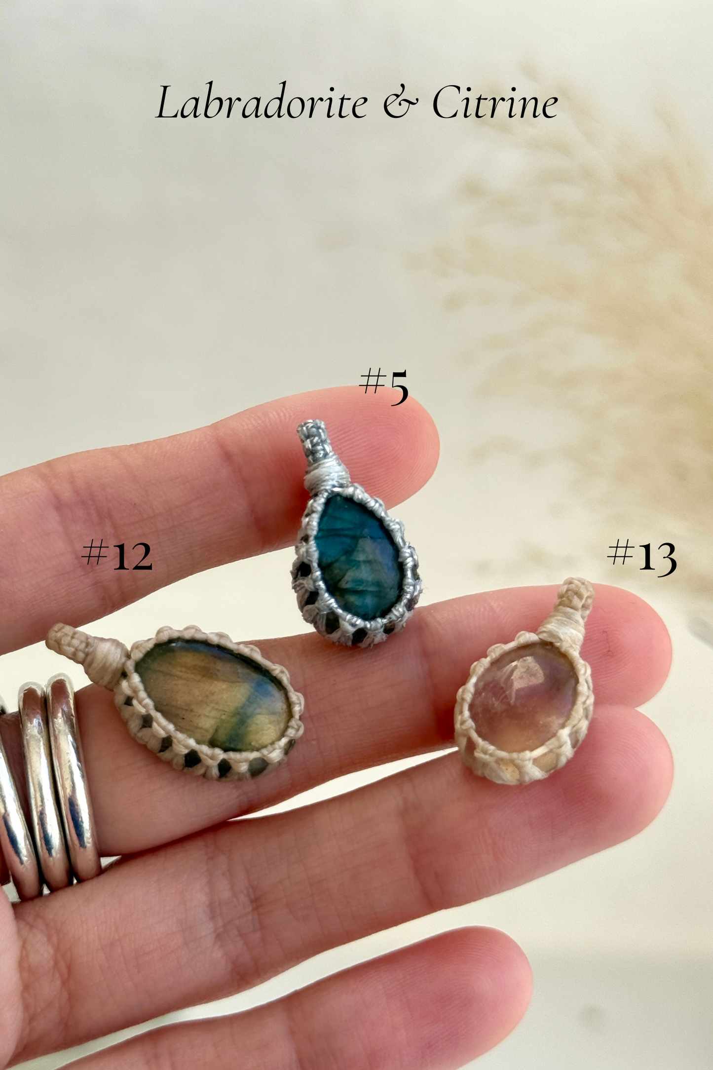 Close-up of Candy Charms featuring Labradorite and Citrine pendants held in hand, showing the size of the charm and detailed gemstone features.