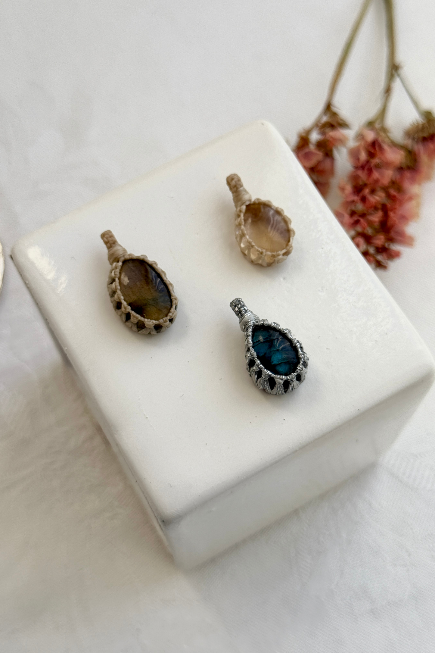 Close-up view of handmade Candy Charms with natural Labradorite and Citrine gemstone pendants, showcasing the macrame wrapping and unique stone details.