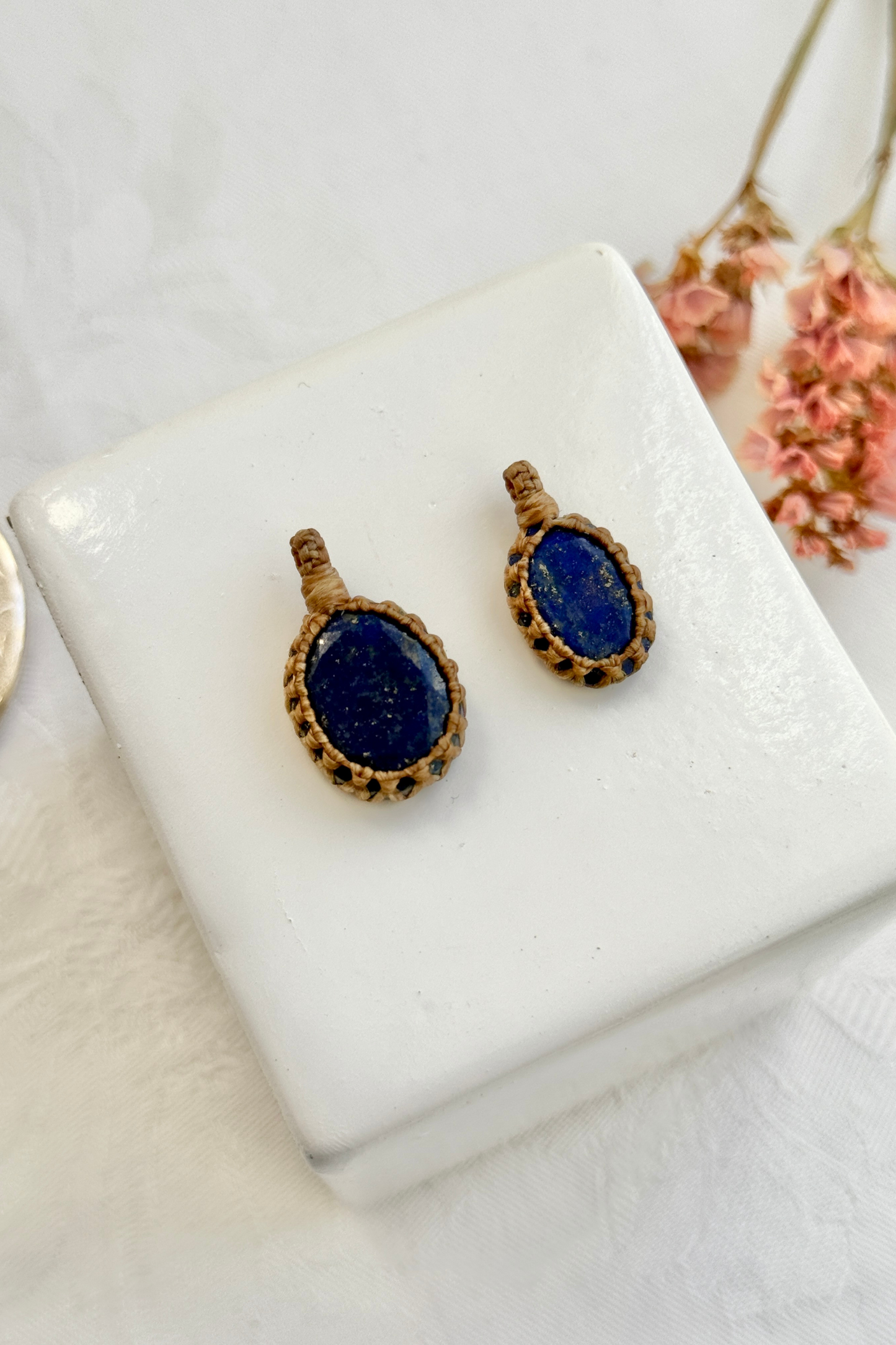 Close-up view of handmade Candy Charms with natural Lapis Lazuli gemstone pendants, showcasing the macrame wrapping and unique stone details.