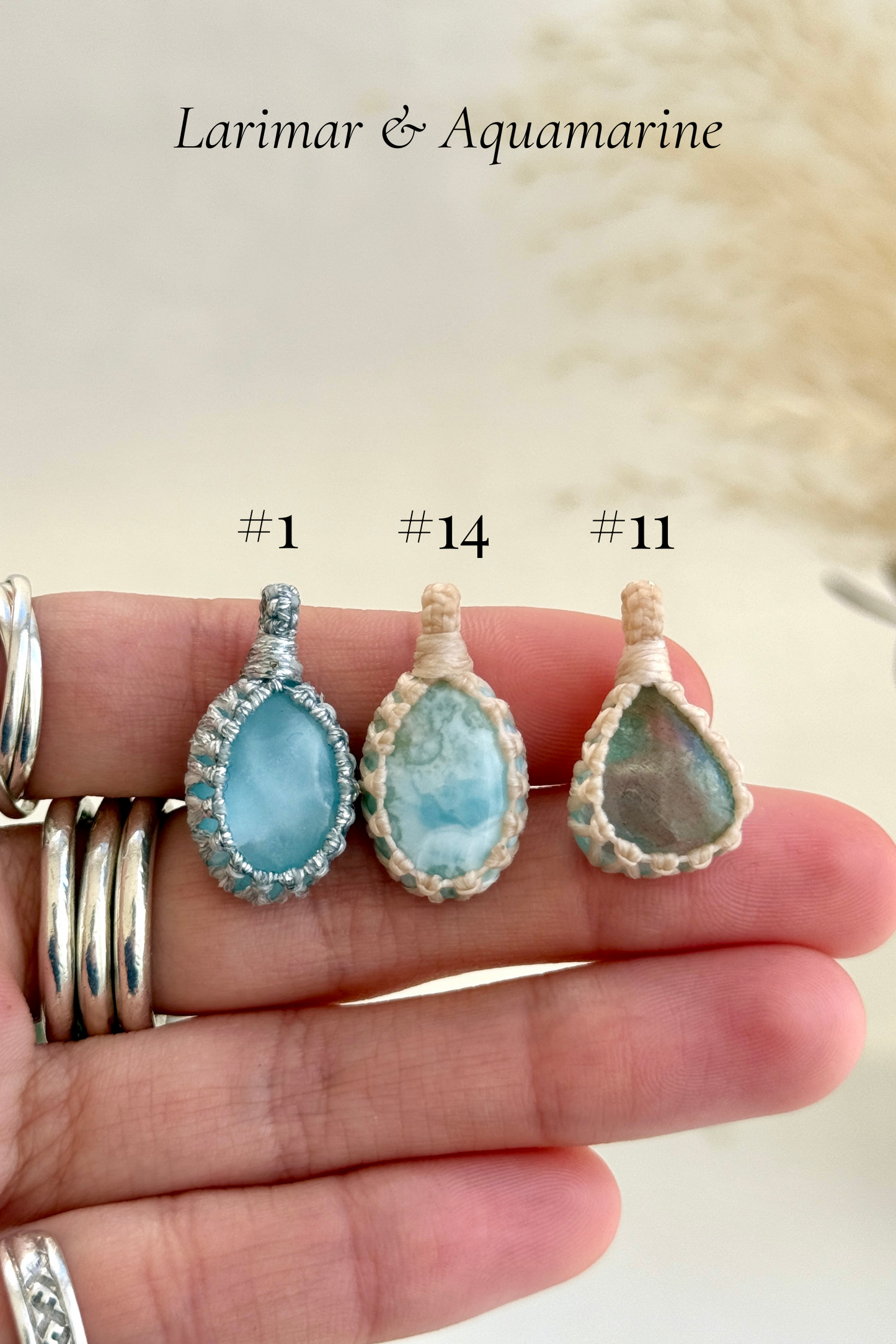 Close-up of Candy Charms featuring Larimar and Aquamarine pendants held in hand, showing the size of the charm and detailed gemstone features.