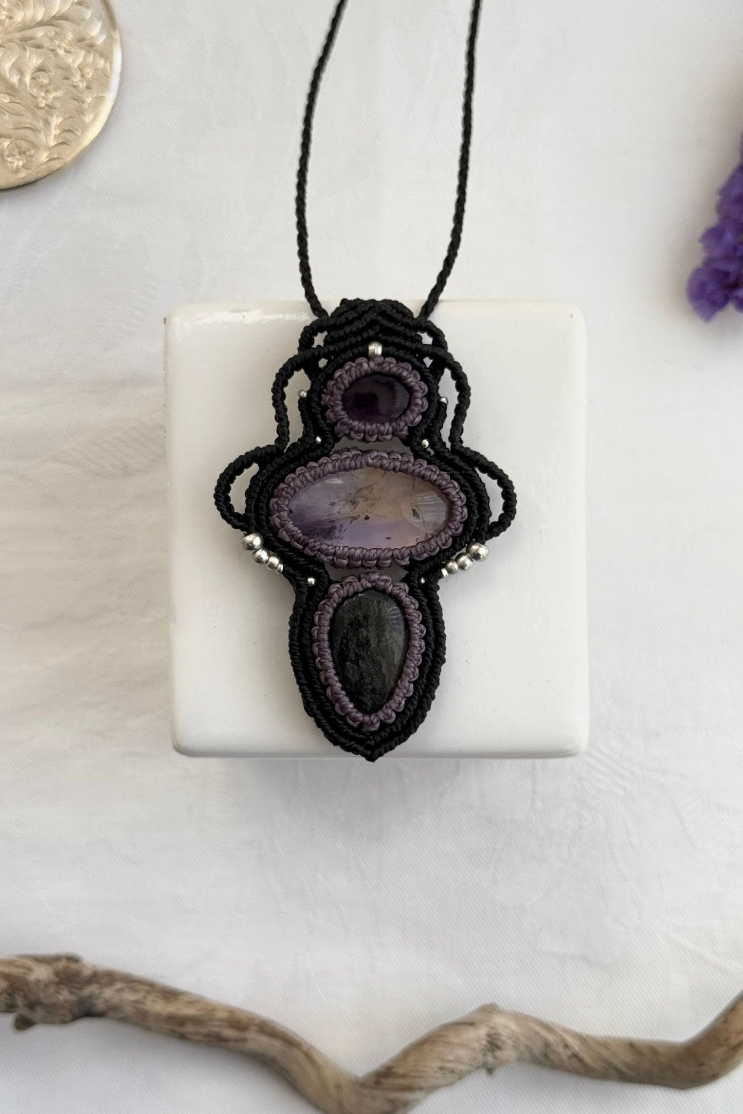 Handmade macrame necklace with Amethyst, Ametrine and Silver Sheen Obsidian gemstones, part of the Nocturnal Collection. One-of-a-kind design, laid flat for an artistic display.