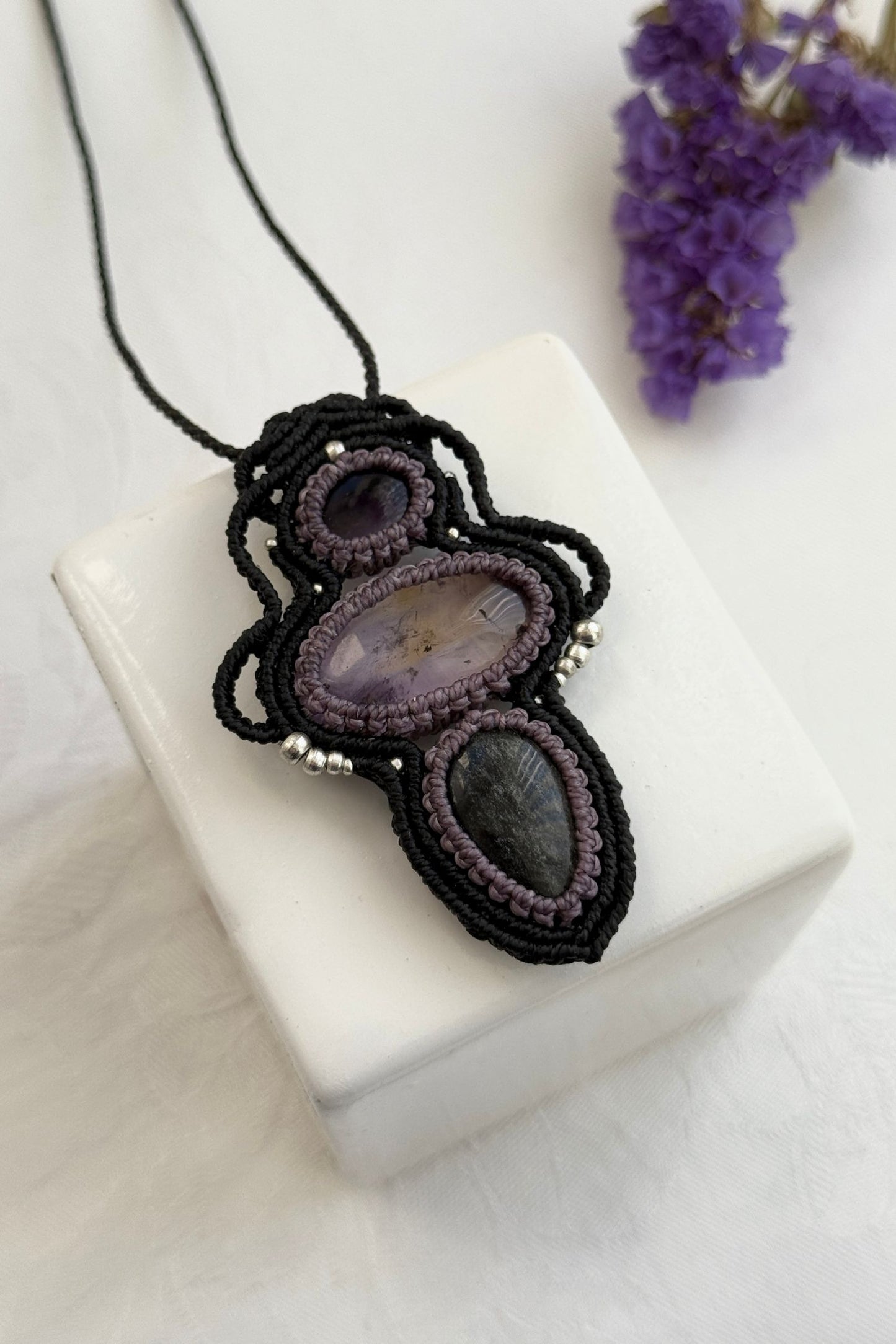 Detailed close-up of Amethyst, Ametrine and Silver Sheen Obsidian gemstones in a handmade macrame necklace. Showcasing natural textures and gemstone glow.