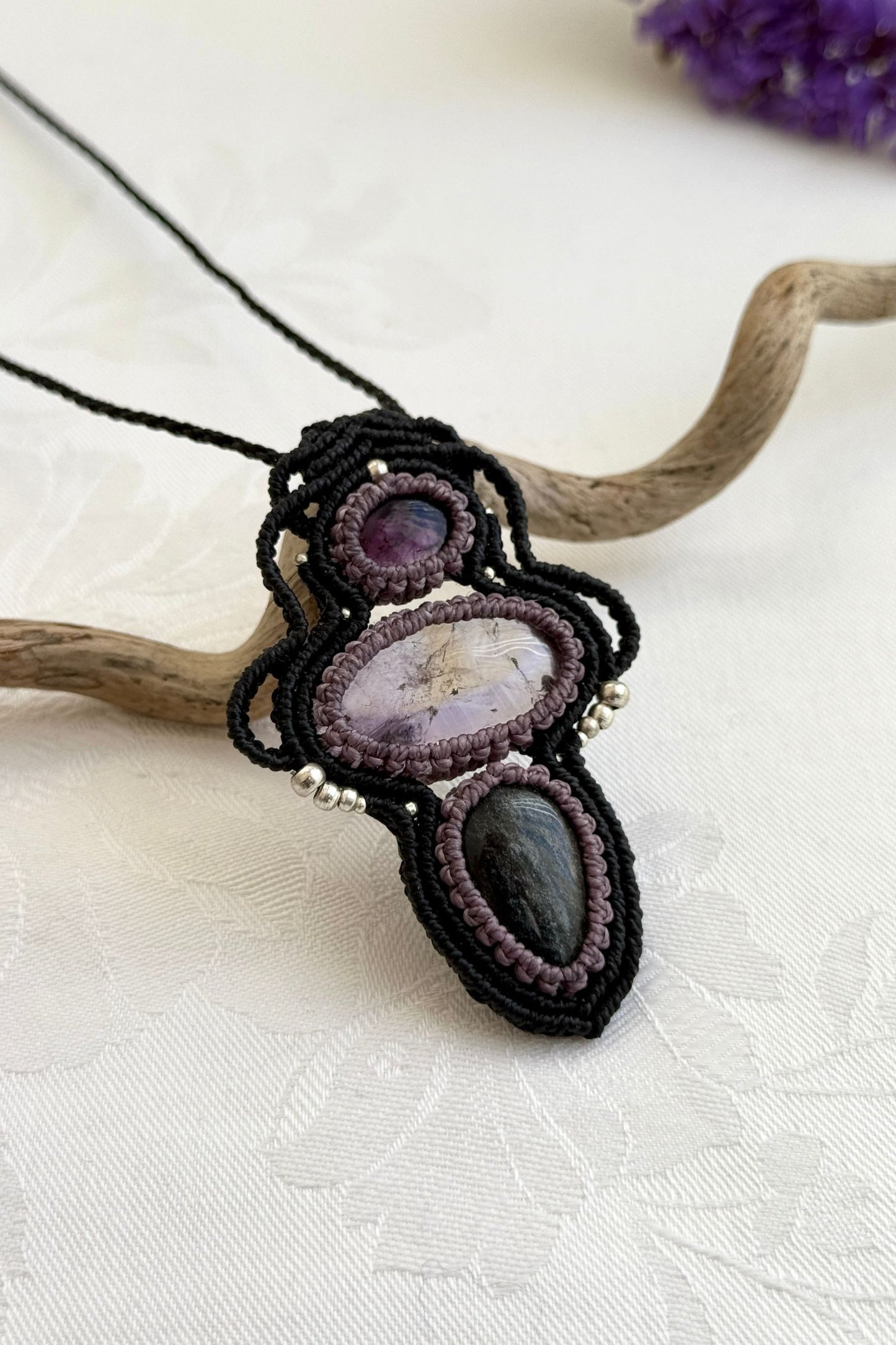 Side-angle view of the handmade macrame necklace with Amethyst, Ametrine and Silver Sheen Obsidian. Showcasing depth, knotting details, and stone textures.