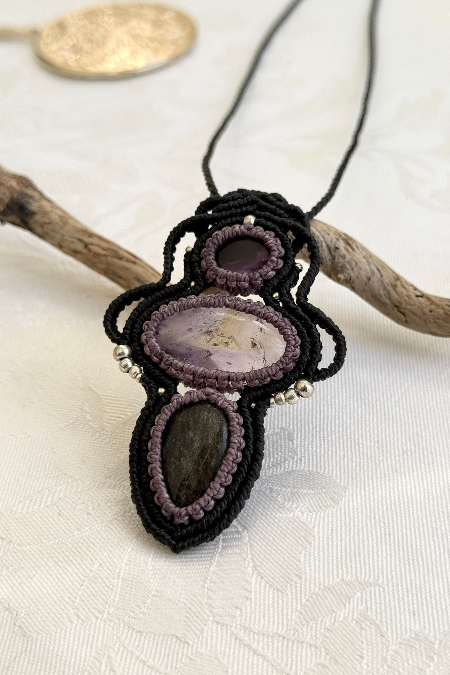Another side-angle view of the handmade macrame necklace with Amethyst, Ametrine and Silver Sheen Obsidian. Showcasing depth, knotting details, and stone textures.
