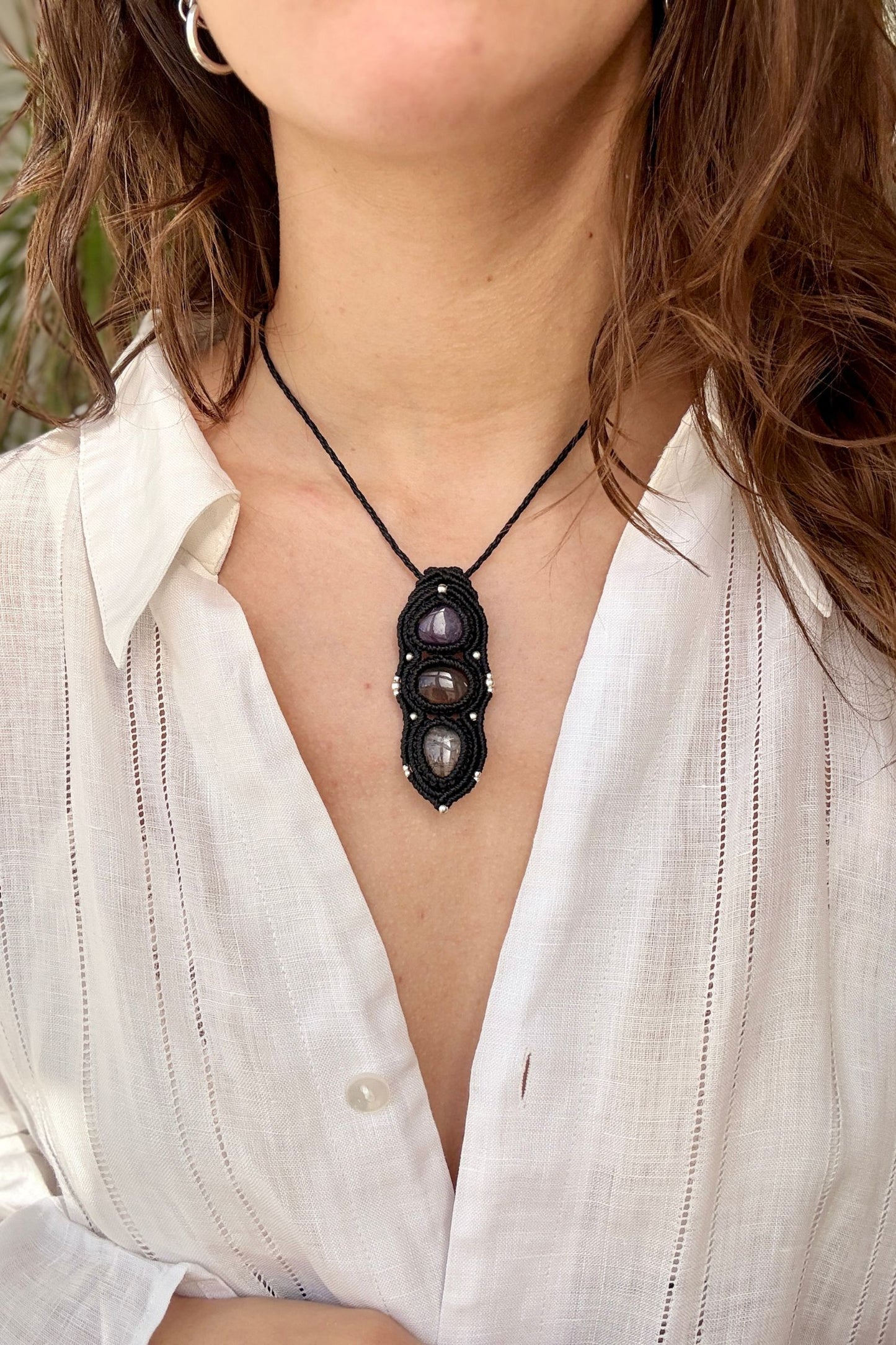 Amethyst, Smoky Quartz and Tourmaline Quartz macrame necklace worn by a model. Showcasing the unique handmade design and how it looks when worn.
