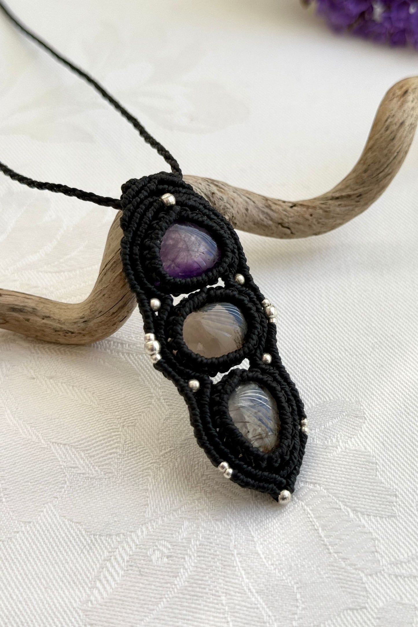 Side-angle view of the handmade macrame necklace with Amethyst, Smoky Quartz and Tourmaline Quartz. Showcasing depth, knotting details, and stone textures.