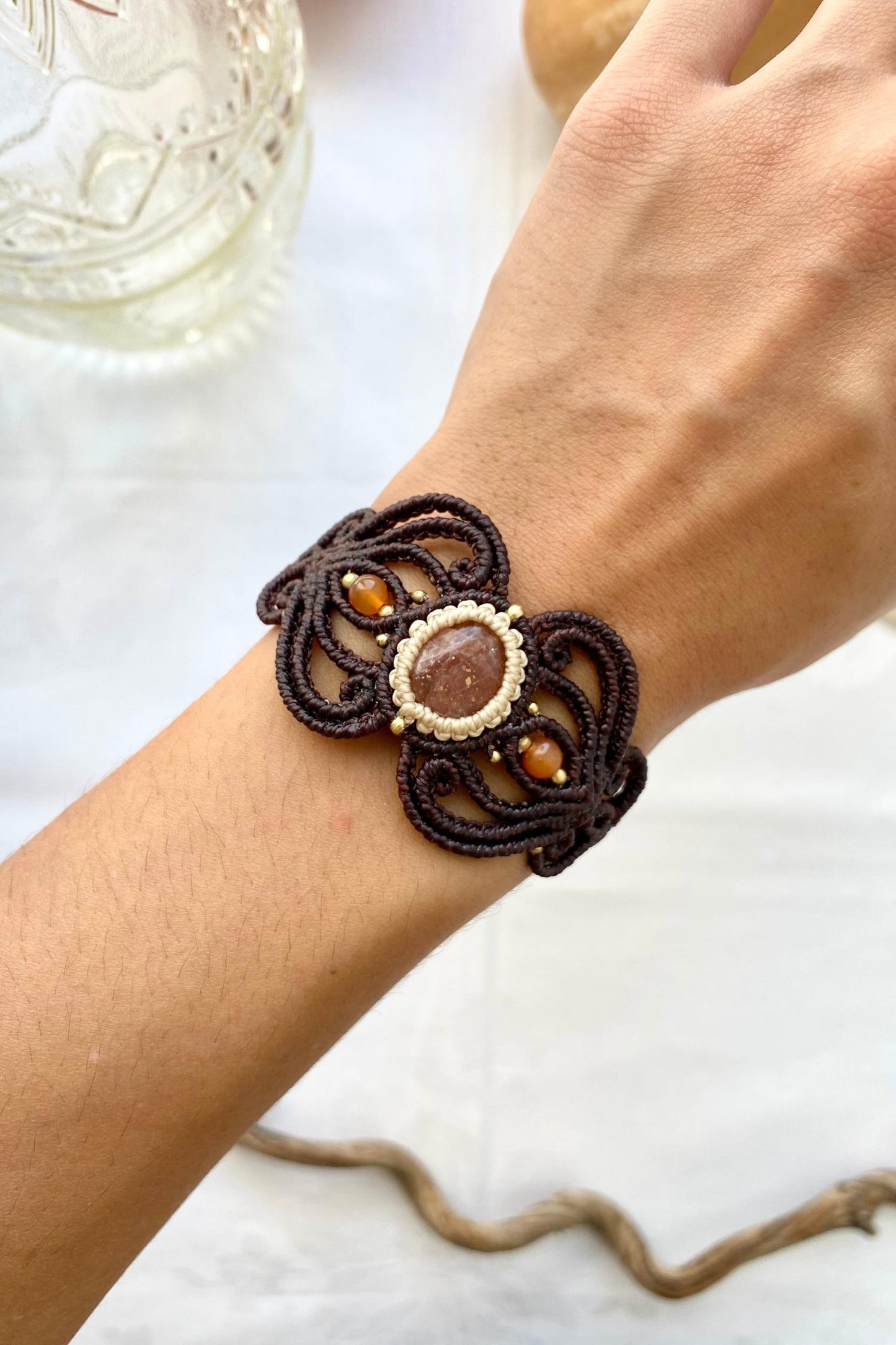 Handmade bracelet featuring a central Sunstone gemstone with two carnelian accents, crafted with a unique design. The bracelet is adjustable for a perfect fit and offers a stylish, comfortable accessory for any occasion.