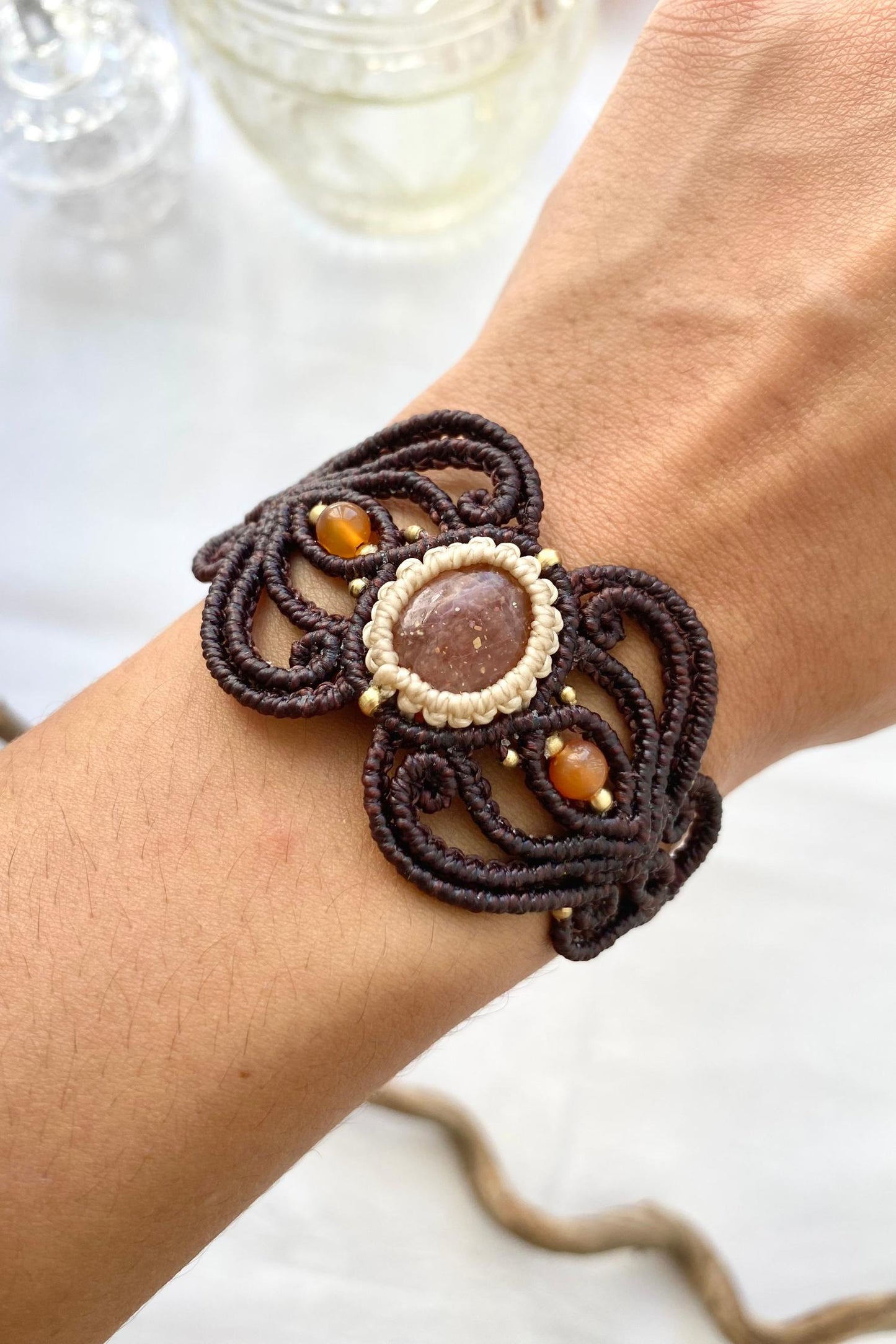 Close-up of the handmade bracelet, highlighting the central Sunstone gemstone brilliance and the two carnelian accents on either side, emphasizing the unique craftsmanship.