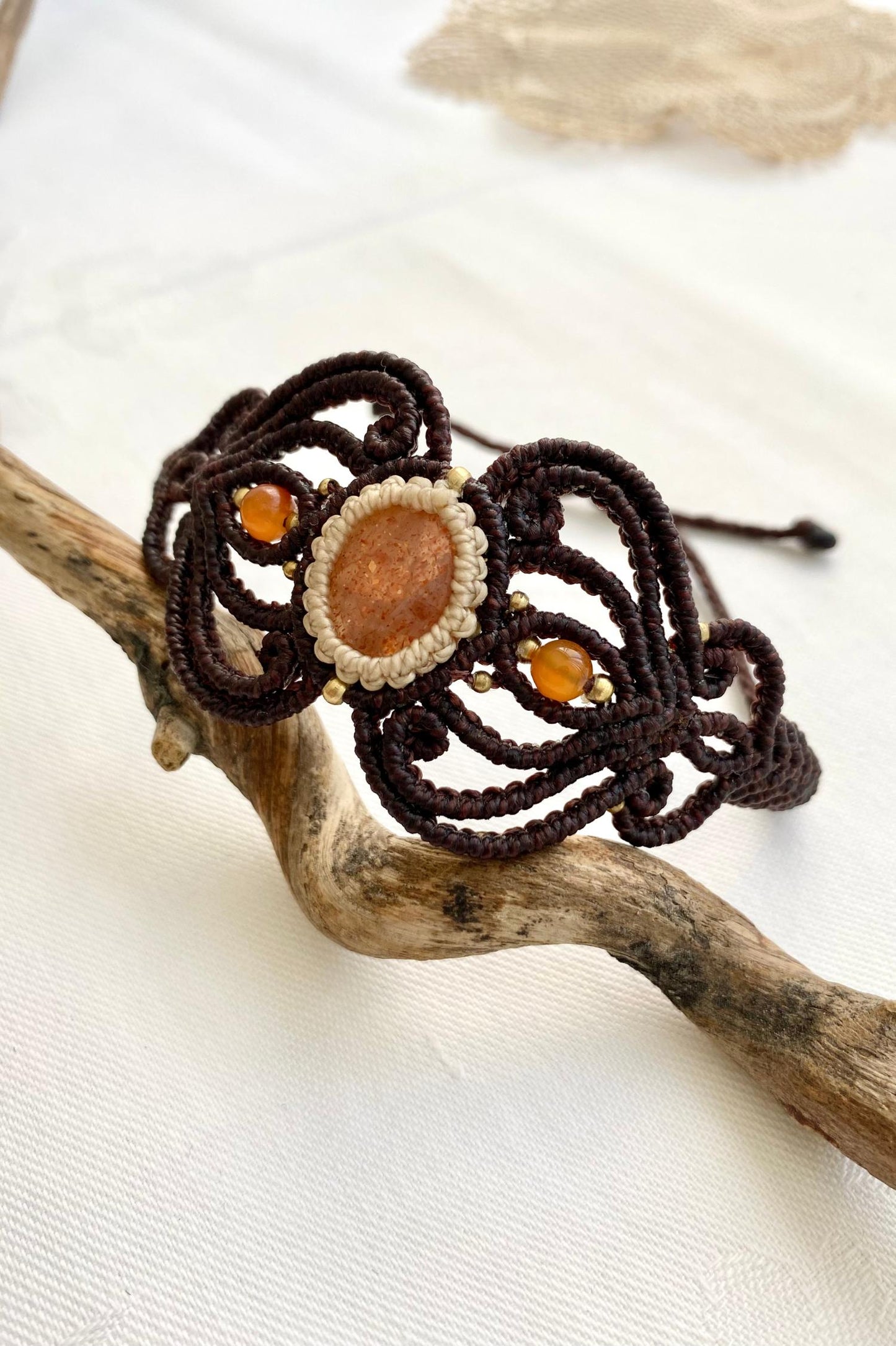 Side view of the bracelet, capturing the delicate design and the adjustable knot closure, ensuring a perfect fit while showcasing the beauty of the Sunstone and carnelian gemstones.