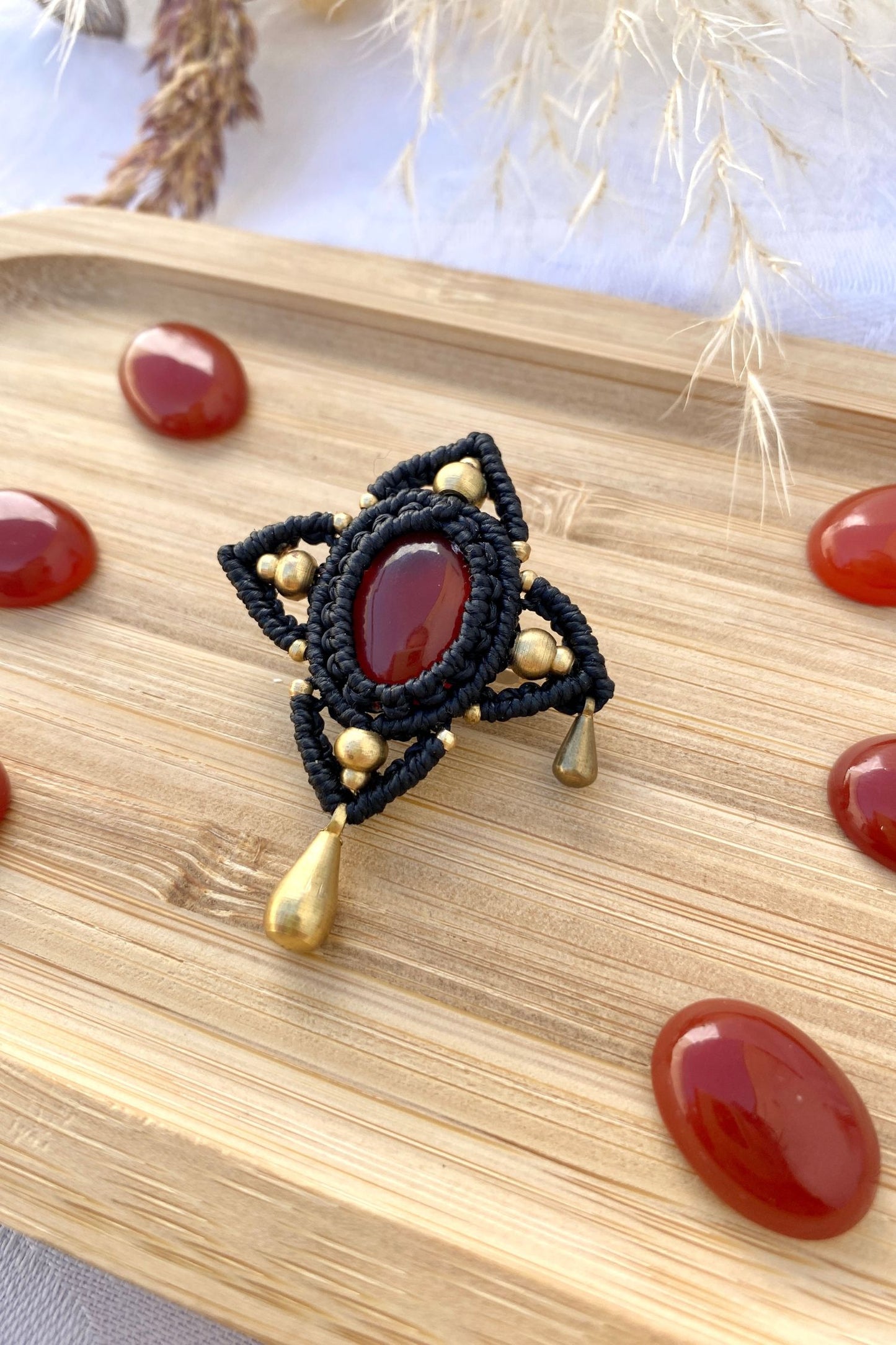 Side view of the handmade statement brooch, showcasing the three-dimensional effect of the Carnelian gemstone and golden drop accents.