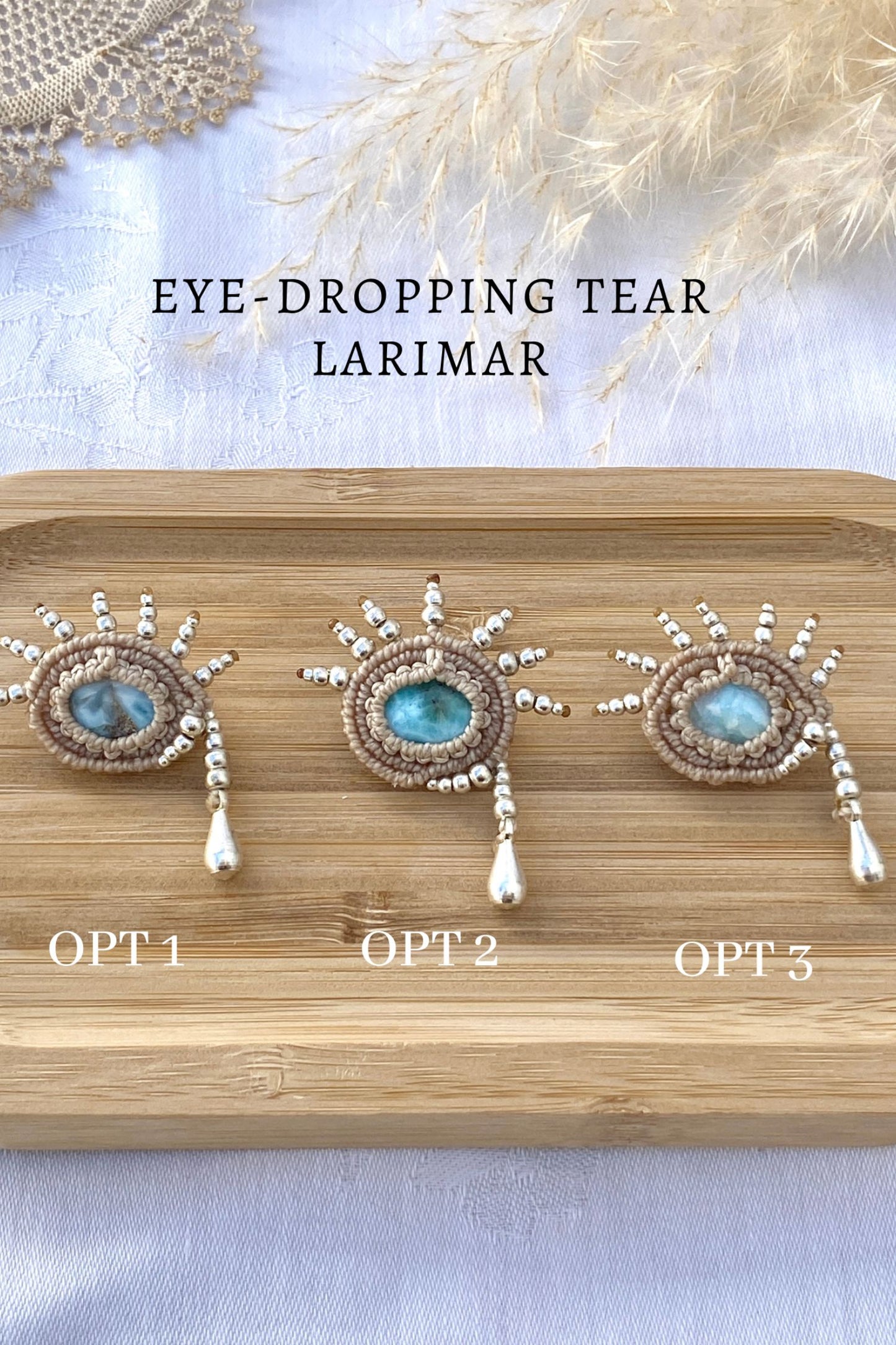 Artistic statement brooch featuring a blue Larimar gemstone and silver teardrop-inspired design, displayed flat to highlight its intricate craftsmanship.