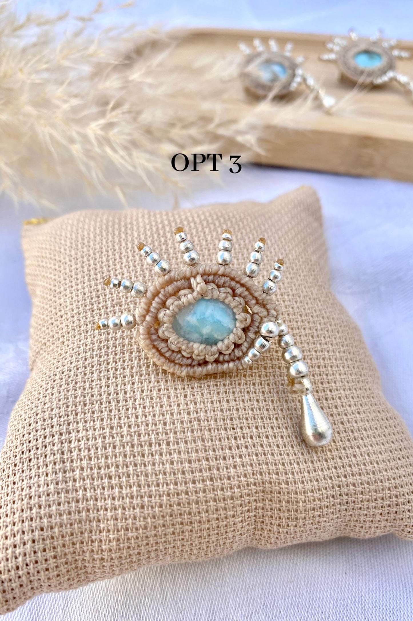 Close-up of the handmade brooch, highlighting the mesmerizing blue hues of the Larimar gemstone and the intricate silver teardrop beadwork.