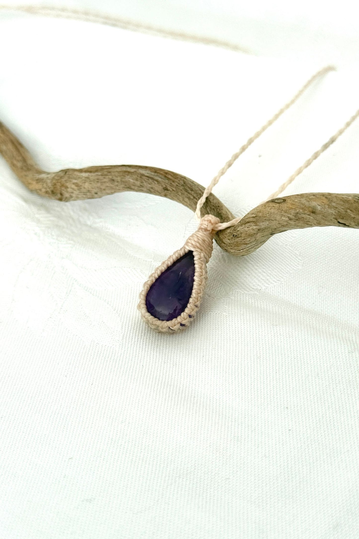 Another side angle shot of the handmade Amethyst Macrame necklace, emphasizing the elegant craftsmanship and natural gemstone colors.