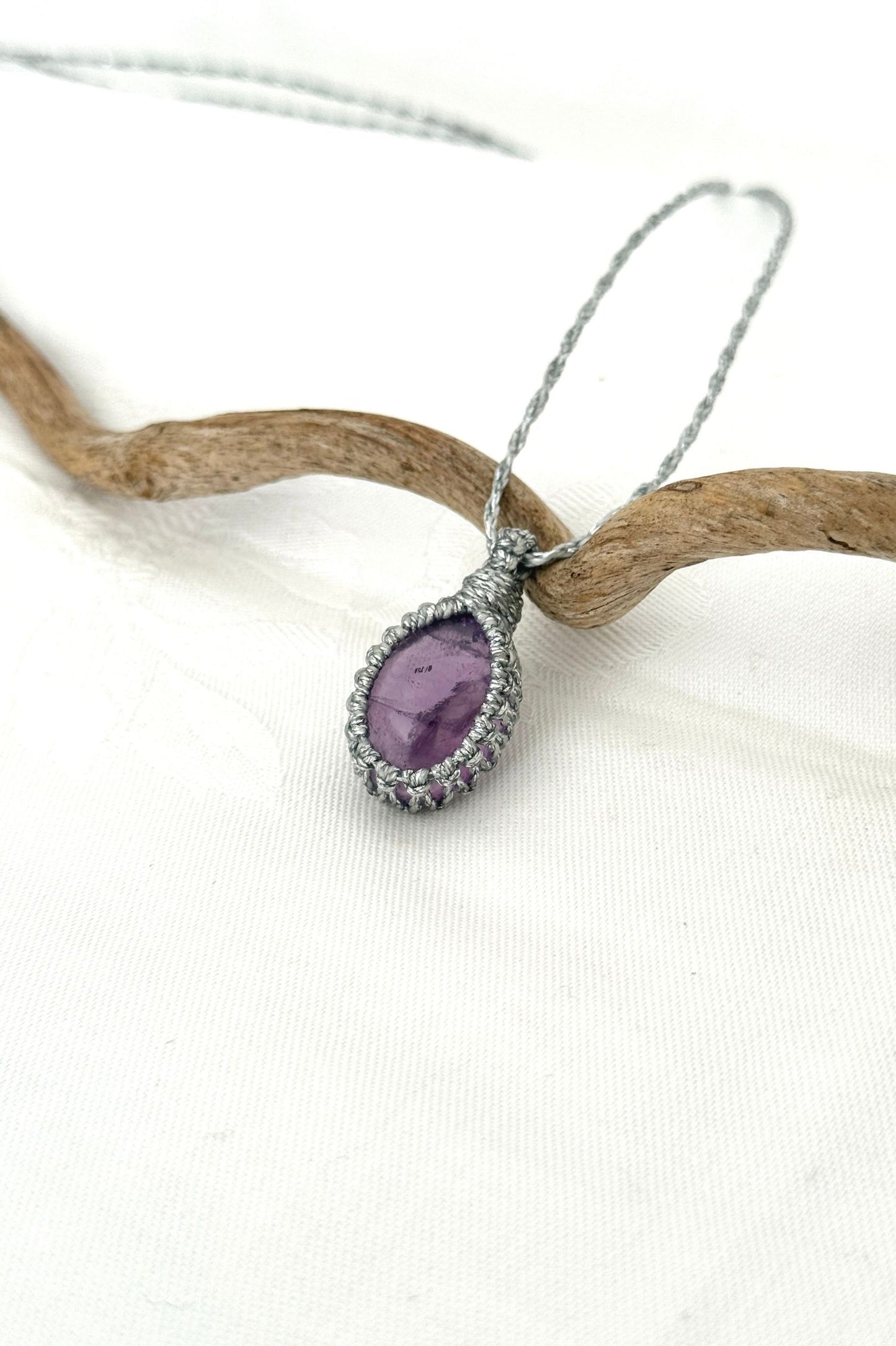 Another side angle shot of the handmade Amethyst Macrame necklace, emphasizing the elegant craftsmanship and natural gemstone colors.