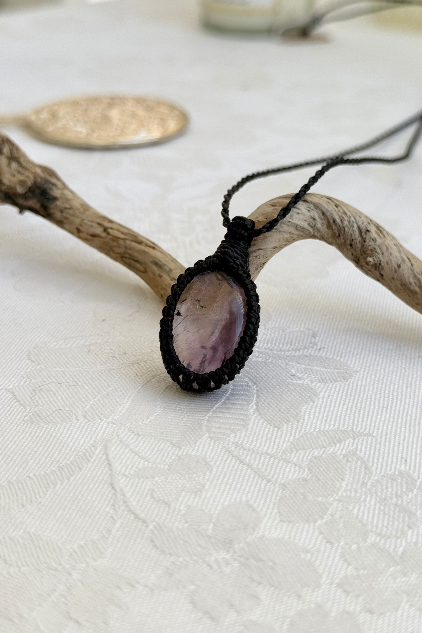 Side view of a Ametrine macrame necklace wrapped in black cord, highlighting its elegant craftsmanship.