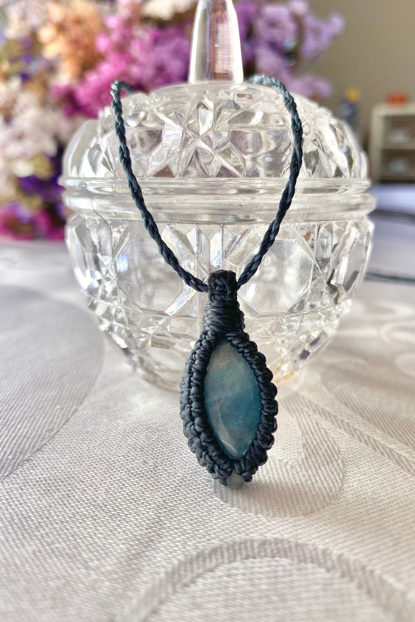 Handmade Aquamarine Macrame necklace displayed standing, highlighting the minimalist macrame design and the natural beauty of the blue gemstone.