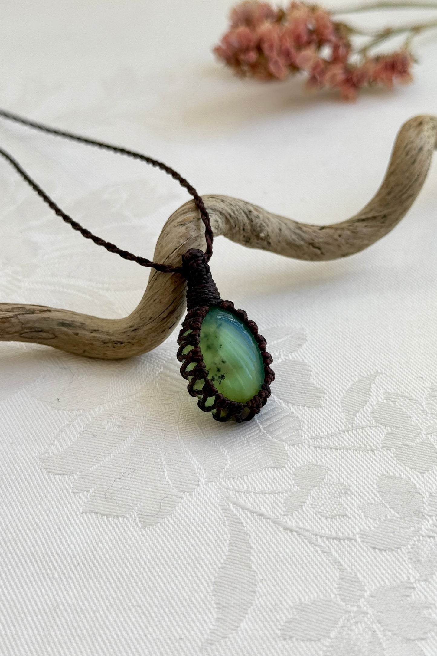 Side view of a Chrysoprase macrame necklace wrapped in brown cord, highlighting its elegant craftsmanship.