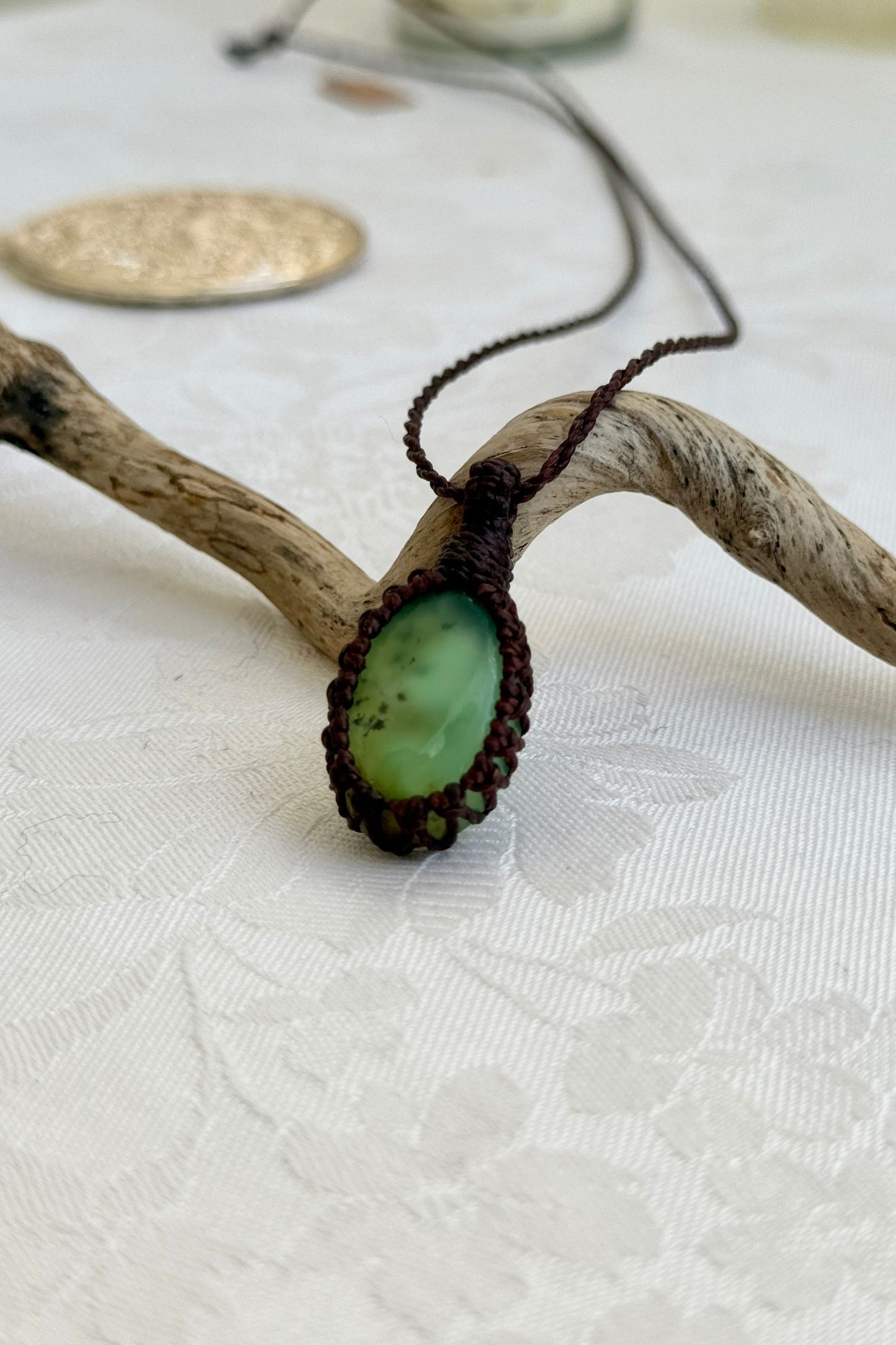 Alternate side view of a handmade Chrysoprase macrame necklace, focusing on the gemstone’s natural glow.