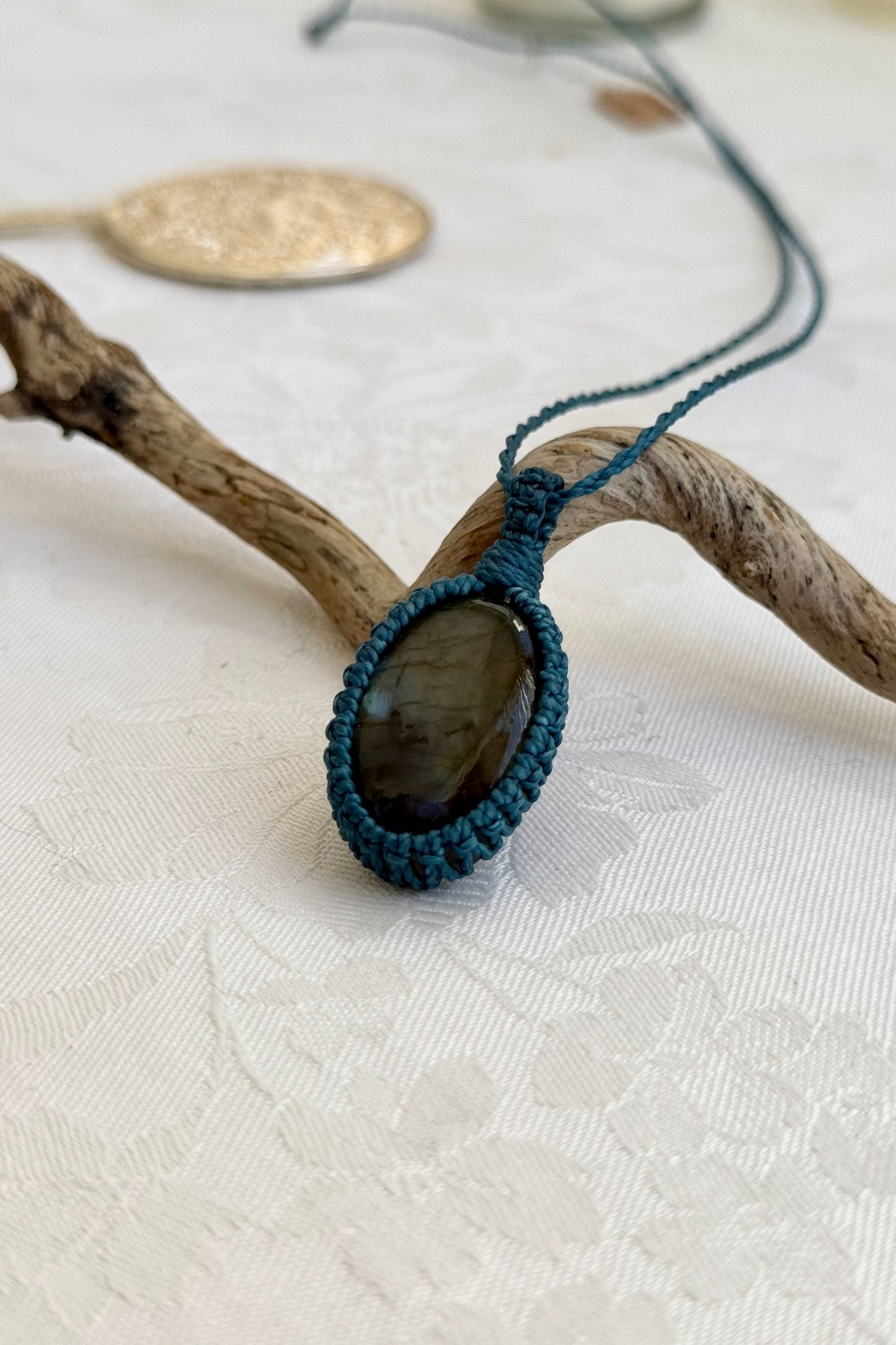 Alternate side view of a handmade Labradorite macrame necklace, focusing on the gemstone’s natural glow.