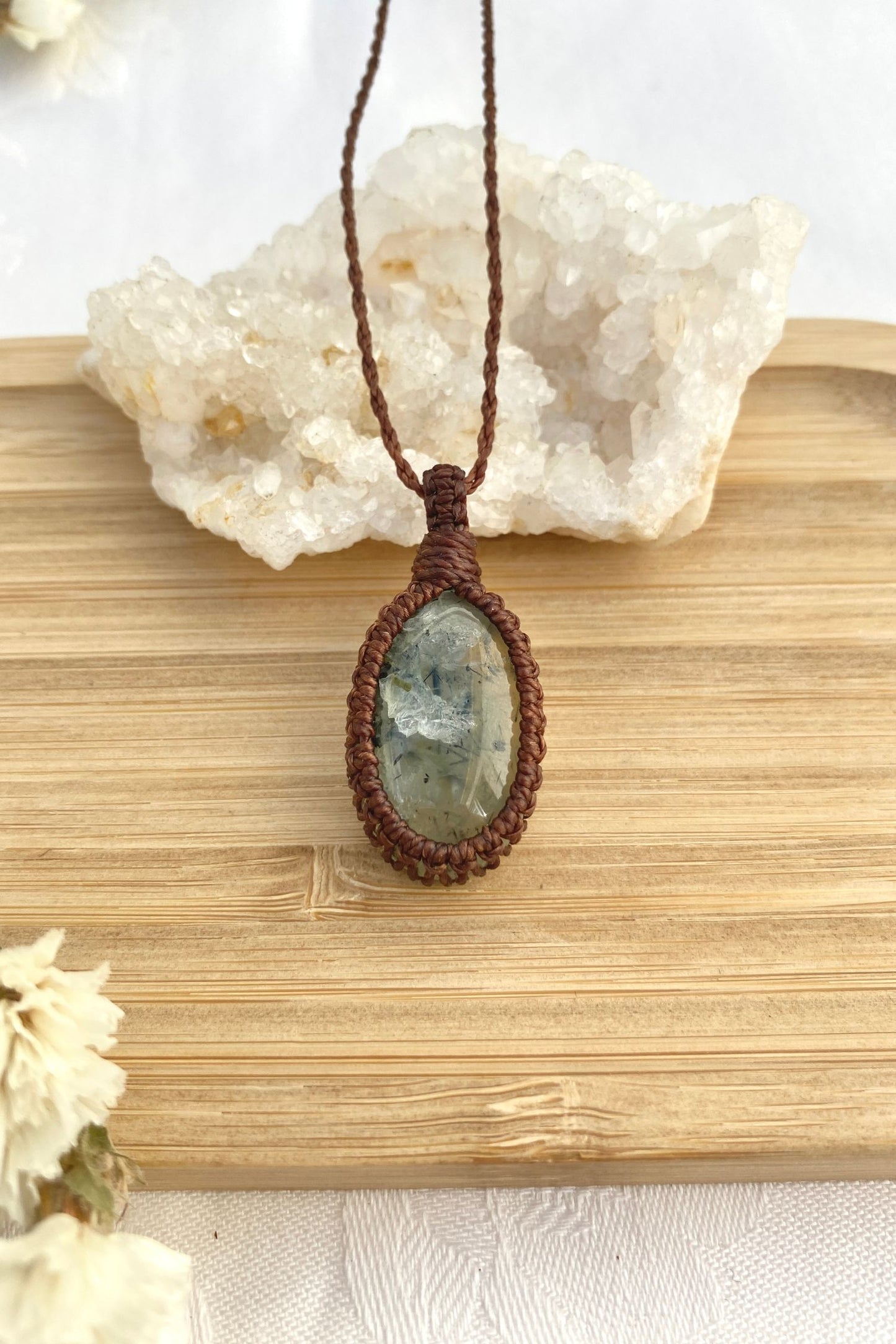 Handmade Prehnite macrame necklace laid flat, showcasing its minimalist design and natural gemstone centerpiece.