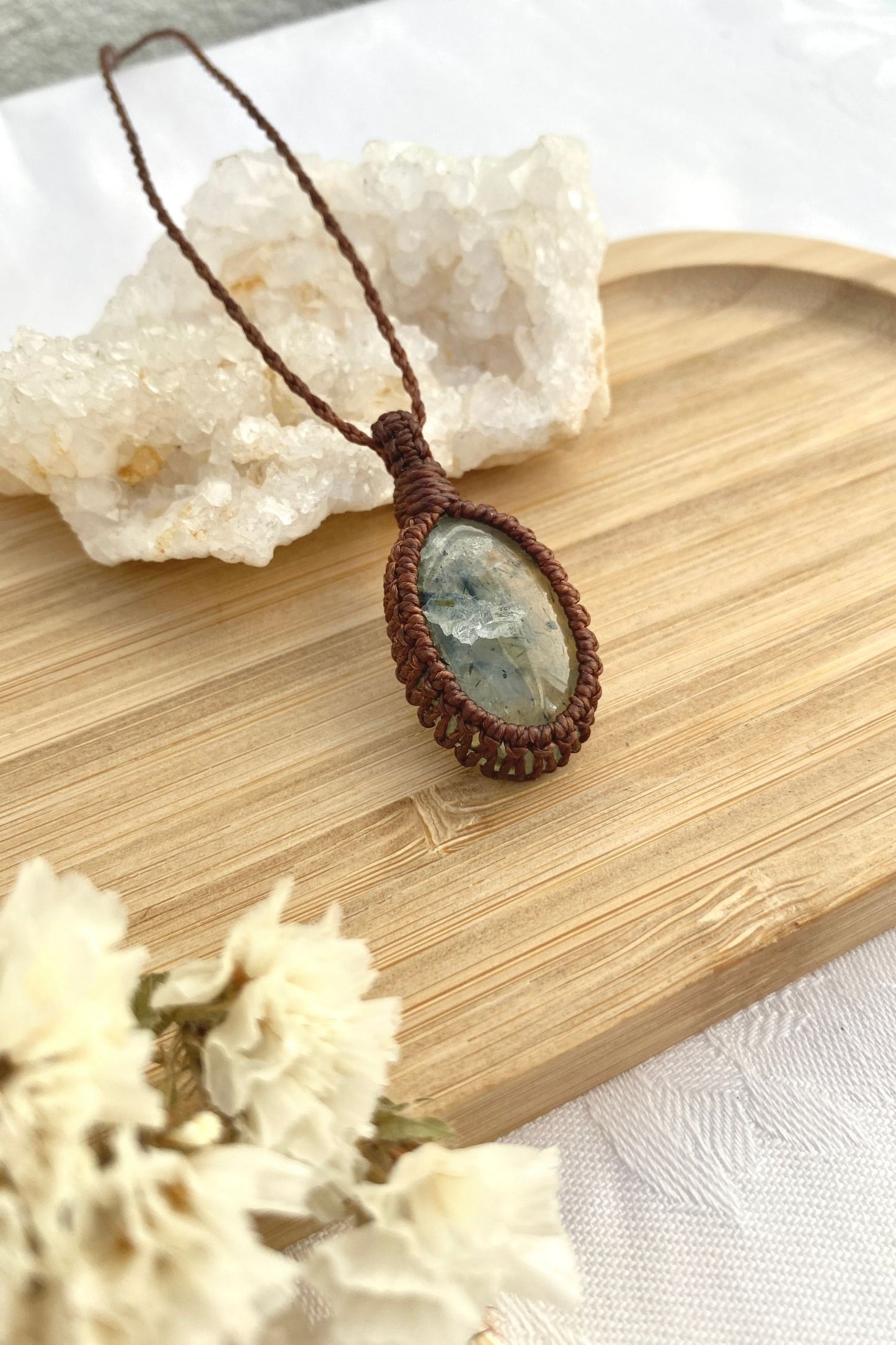 Another side angle view of the handmade Prehnite macrame necklace, highlighting the smooth texture and organic inclusions of the gemstone.