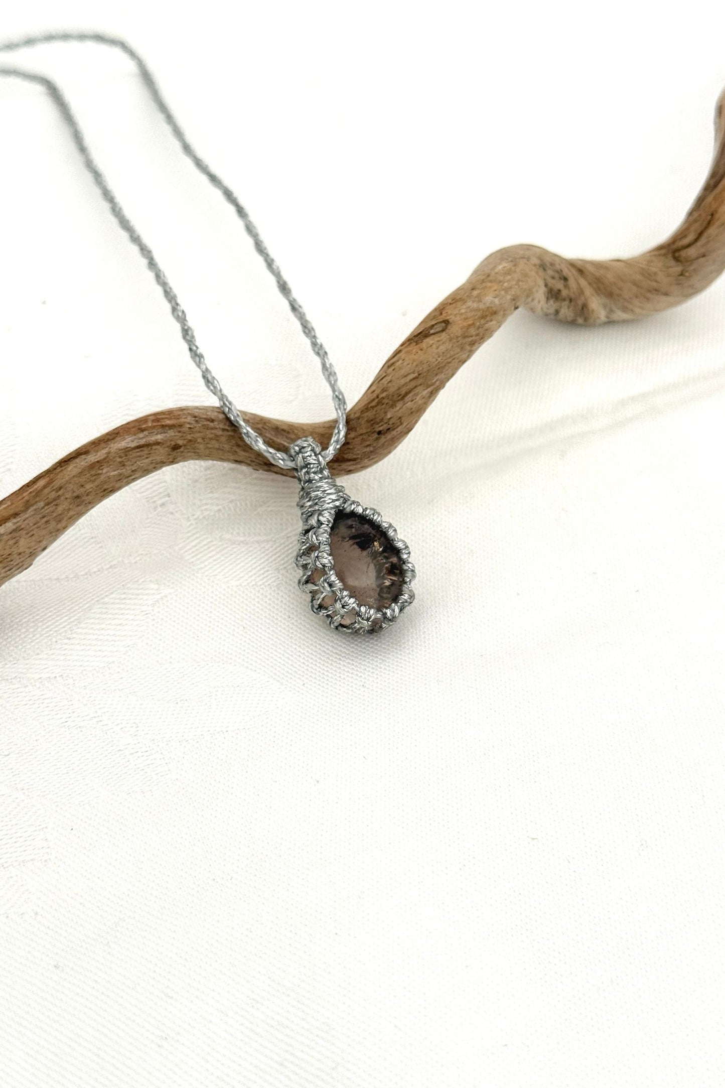 Side angle view of the Smoky Quartz Macrame necklace, showing the fine macrame details and the unique gemstone centerpiece.