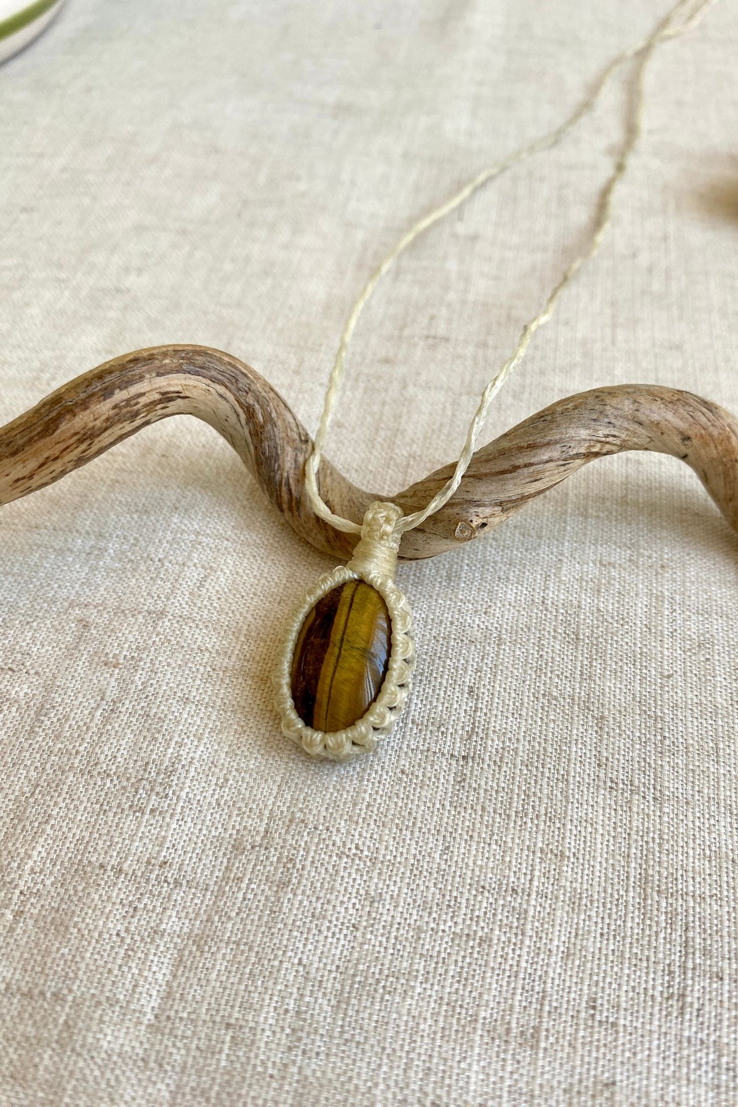 Another side angle view of a handmade Tiger’s Eye macrame necklace, focusing on the beautiful blend of golden-brown tones within the gemstone