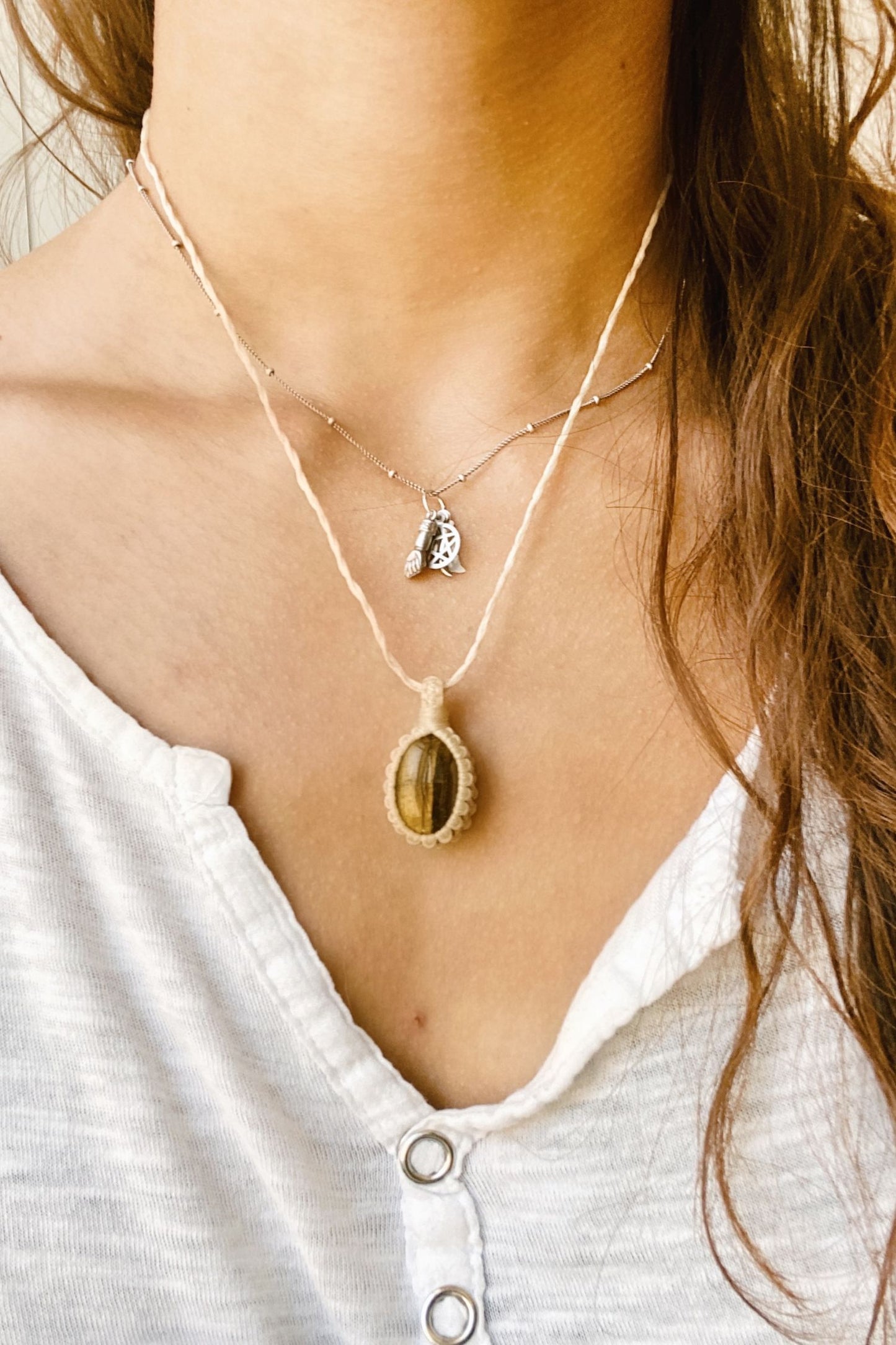 Model wearing a handmade Tiger’s Eye macrame necklace, featuring a unique gemstone with golden-brown bands and a simple, elegant macrame design.