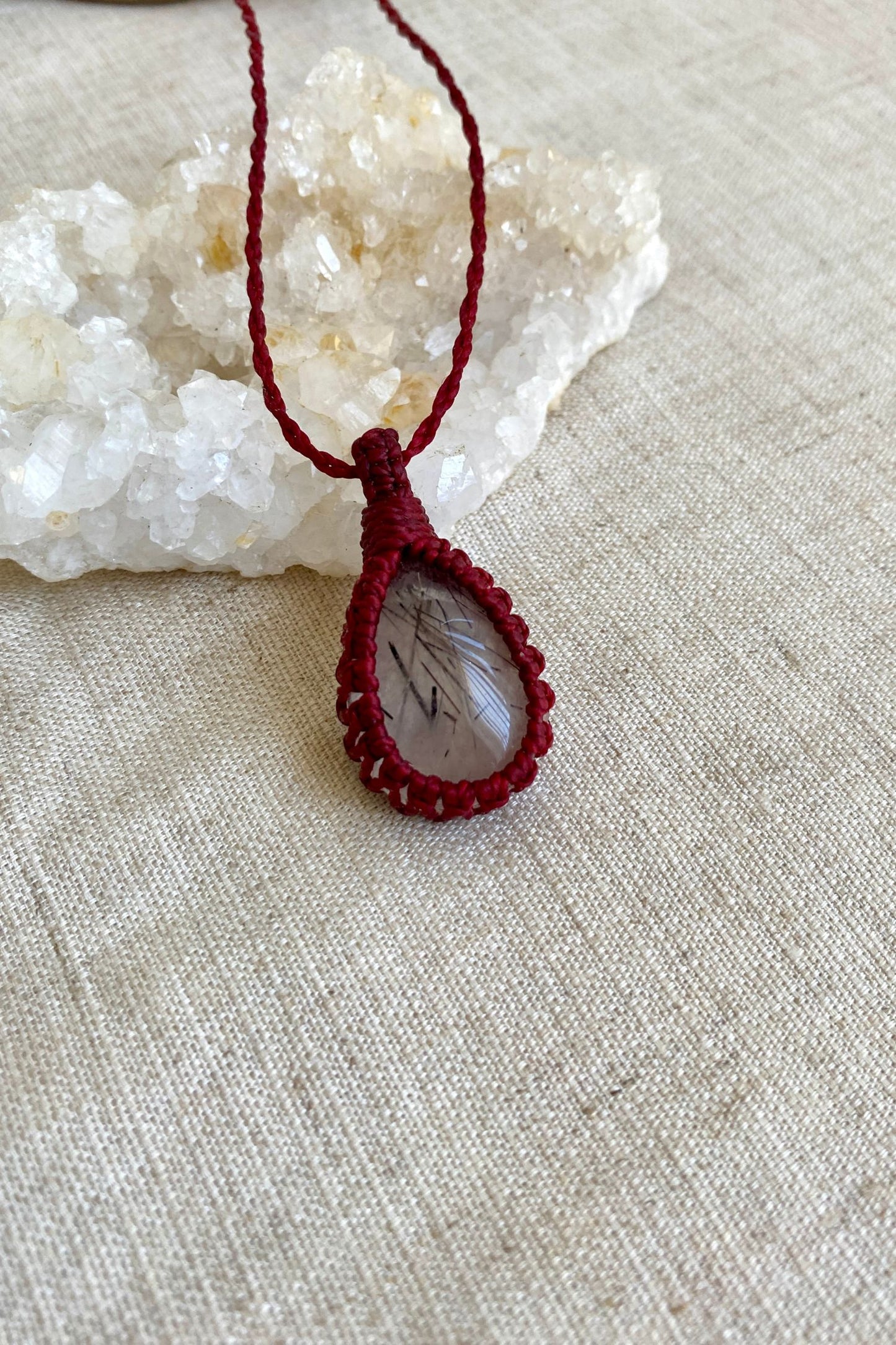 Close-up of a handmade Tourmaline Quartz macrame necklace, highlighting the intricate black tourmaline inclusions within the translucent quartz.