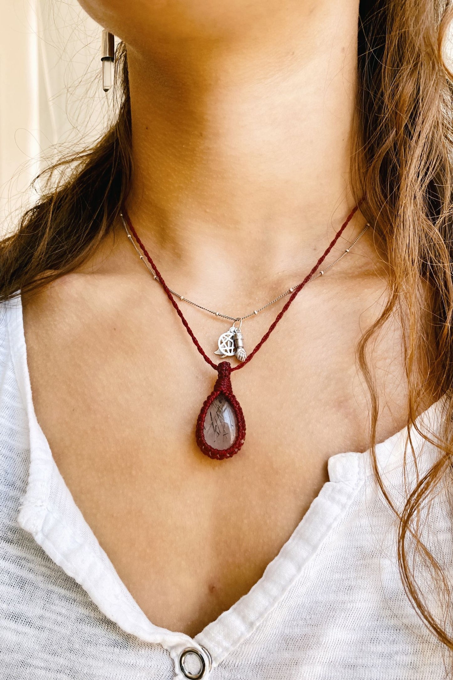 Model wearing a handmade Tourmaline Quartz macrame necklace, featuring a bold red cord that enhances the gemstone’s natural beauty.