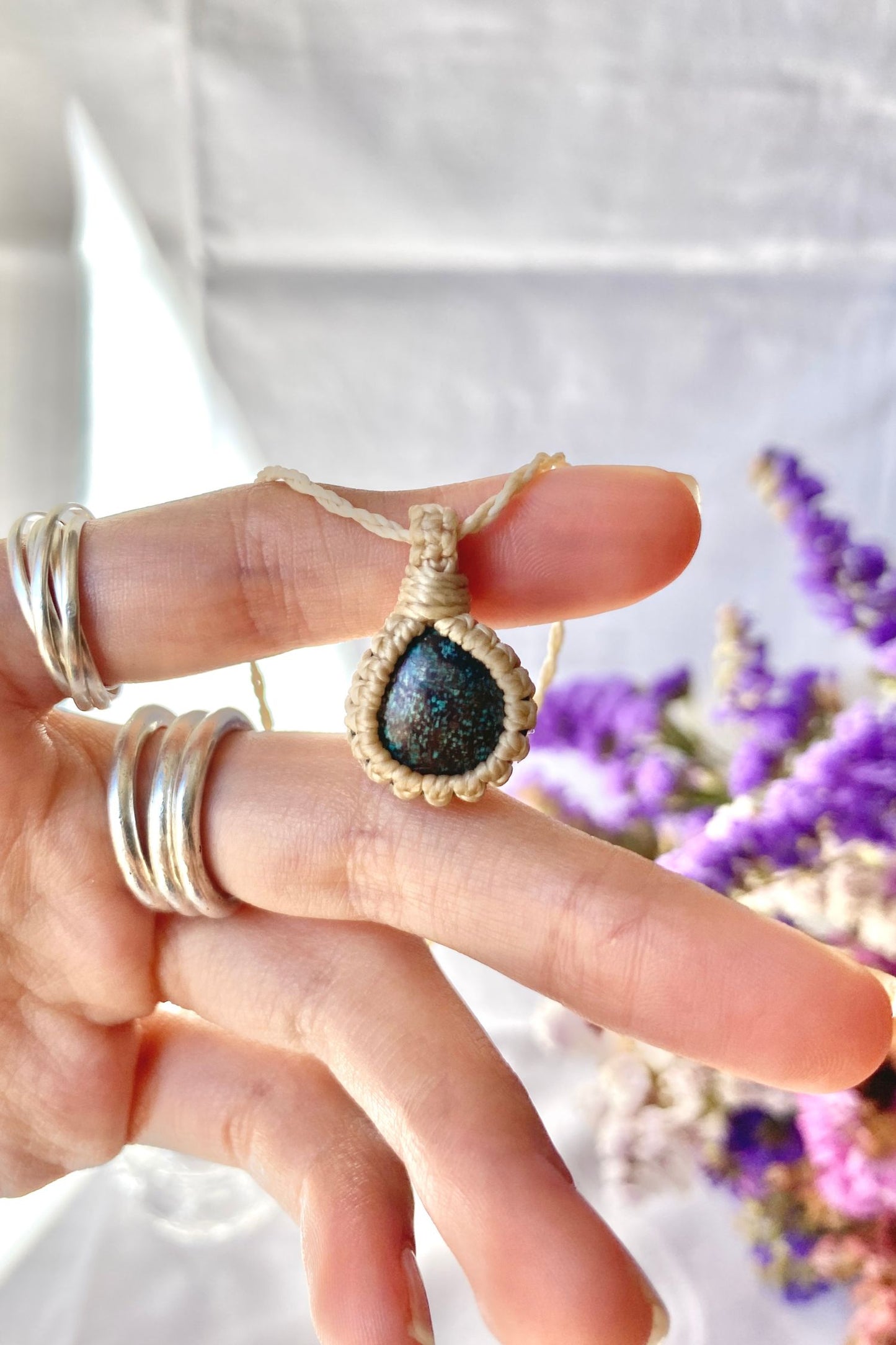 Hand holding a handmade Turquoise Macrame necklace from the Essence collection, featuring a high-quality natural gemstone in a delicate everyday-wear design.