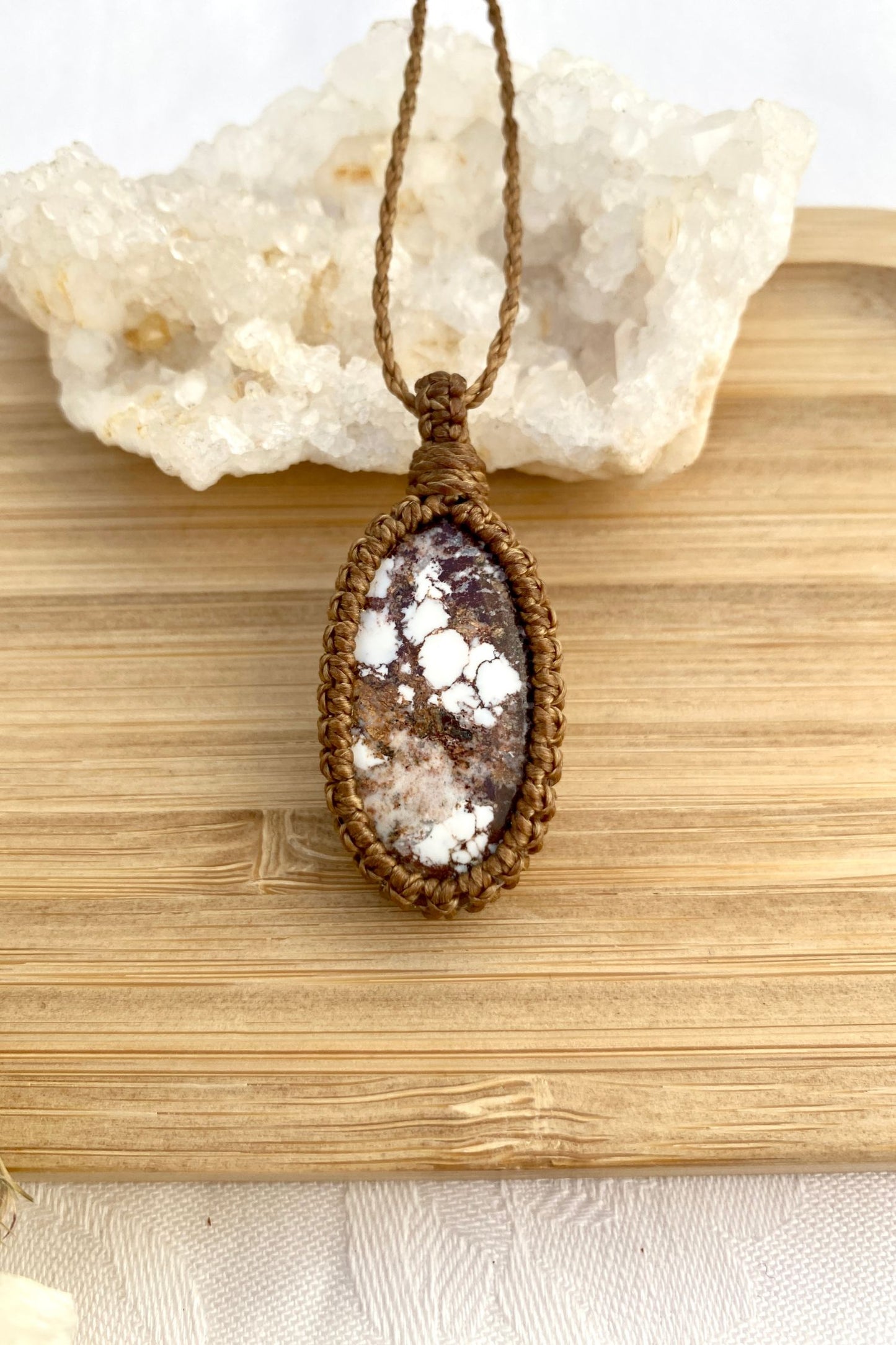 Handmade Wild Horse Magnesite macrame necklace laid flat, emphasizing its earthy gemstone centerpiece and delicate macrame craftsmanship.