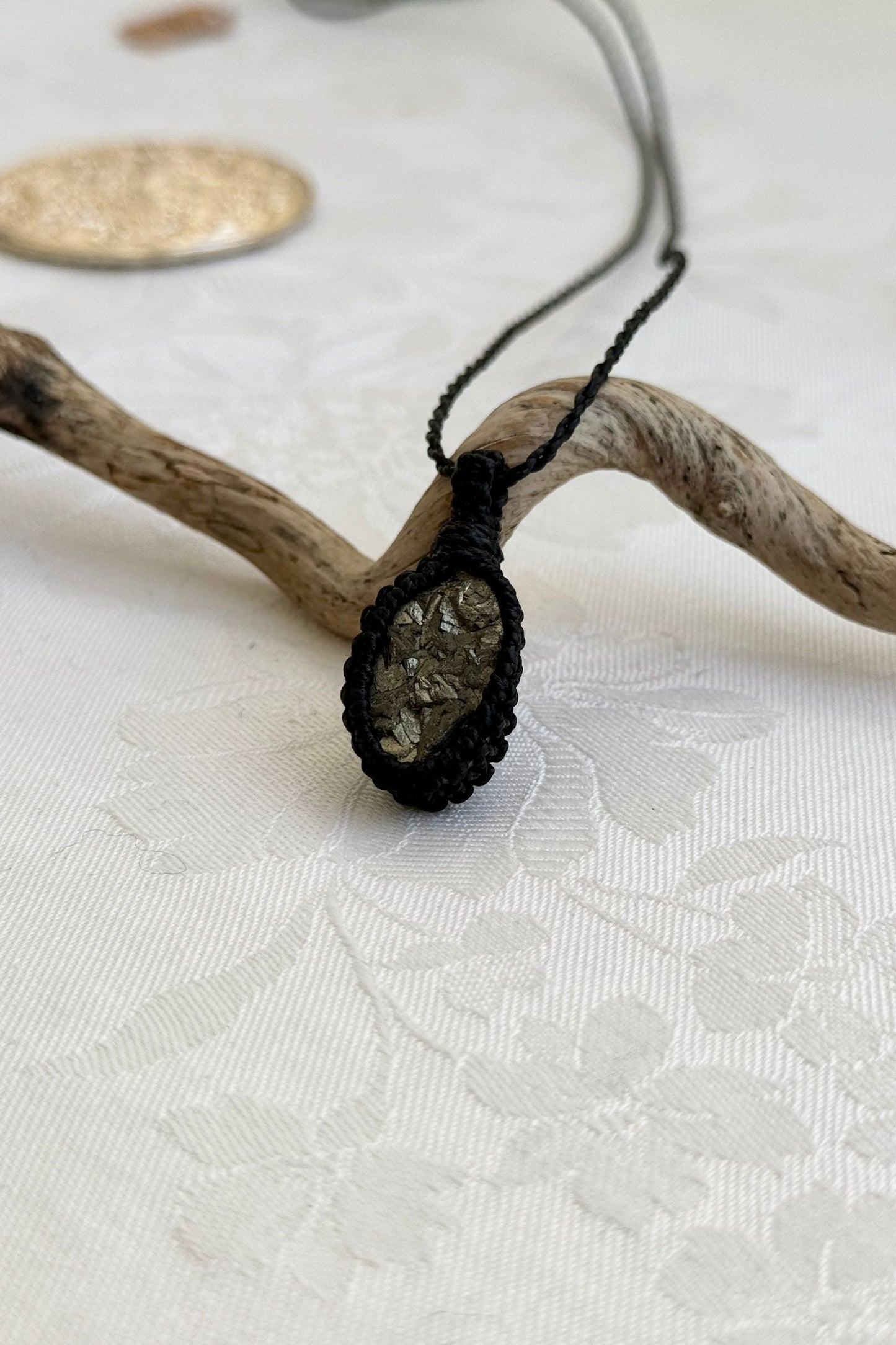 Alternate side view of a handmade Raw Pyrite macrame necklace, focusing on the gemstone’s natural glow.