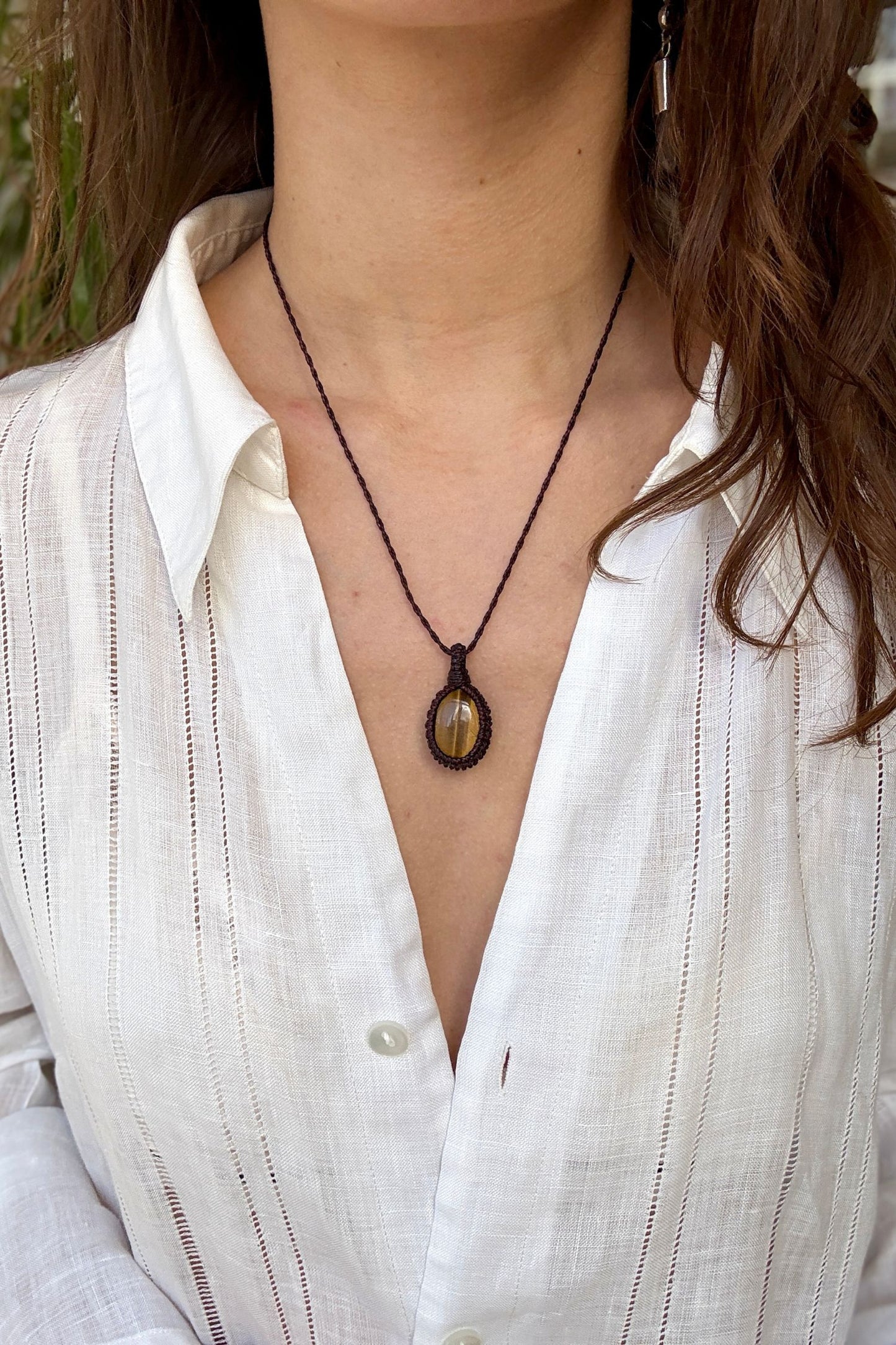Model wearing a delicate handmade Tiger’s Eye macrame necklace with a brown cord, perfect for everyday wear.