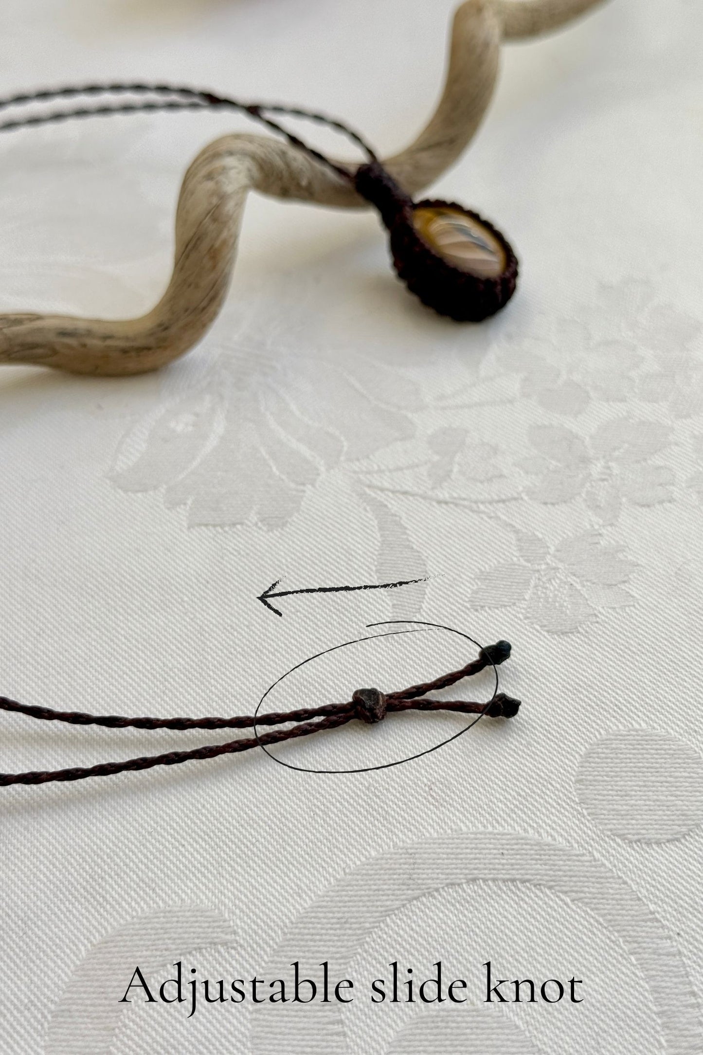 Close-up of the adjustable sliding lock on a handmade Tiger’s Eye macrame necklace, ensuring a perfect fit for all sizes.