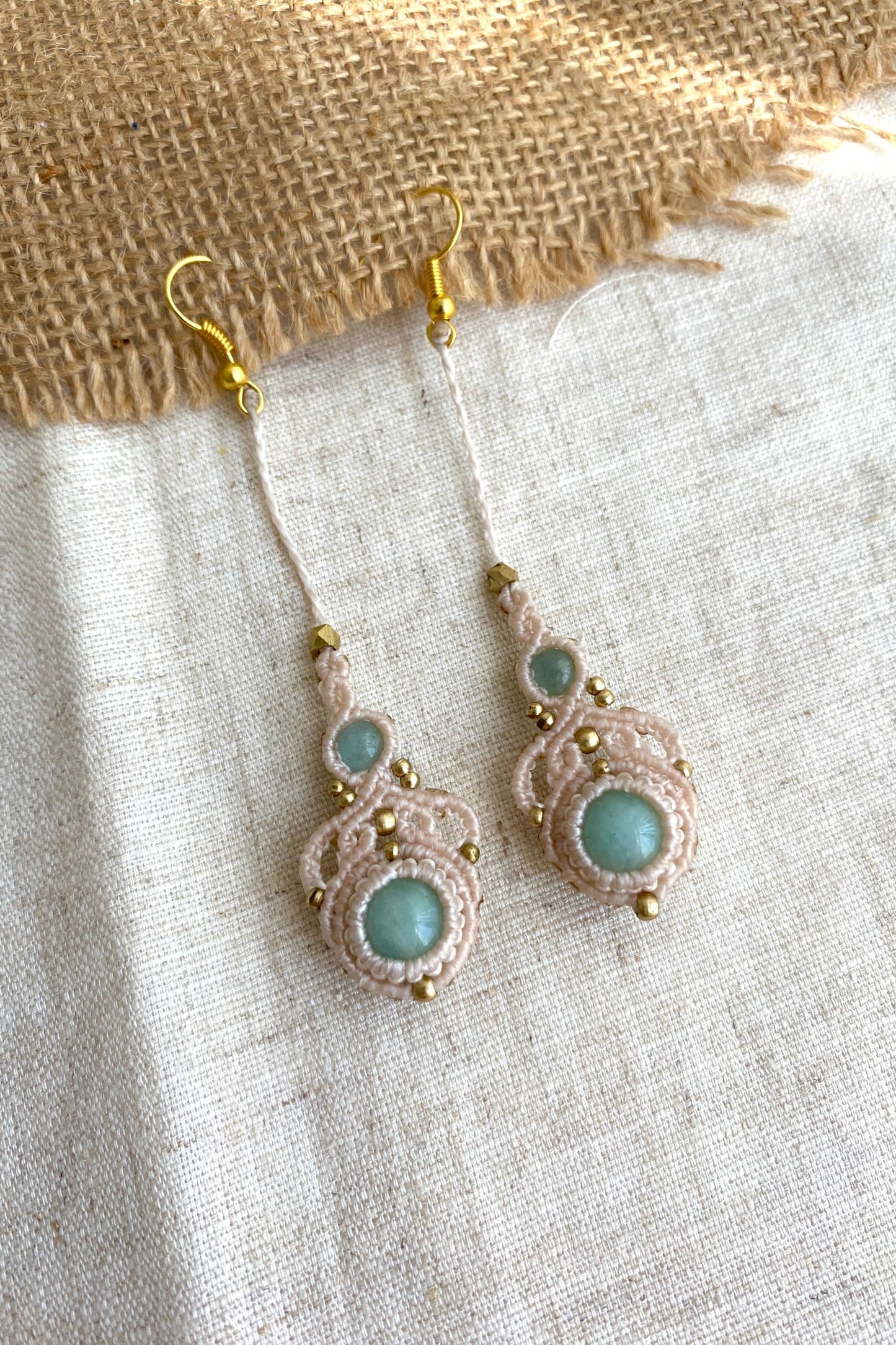 Handmade macrame earrings featuring amazonite and aquamarine gemstones, displayed laid flat to showcase the elegant long drop design.