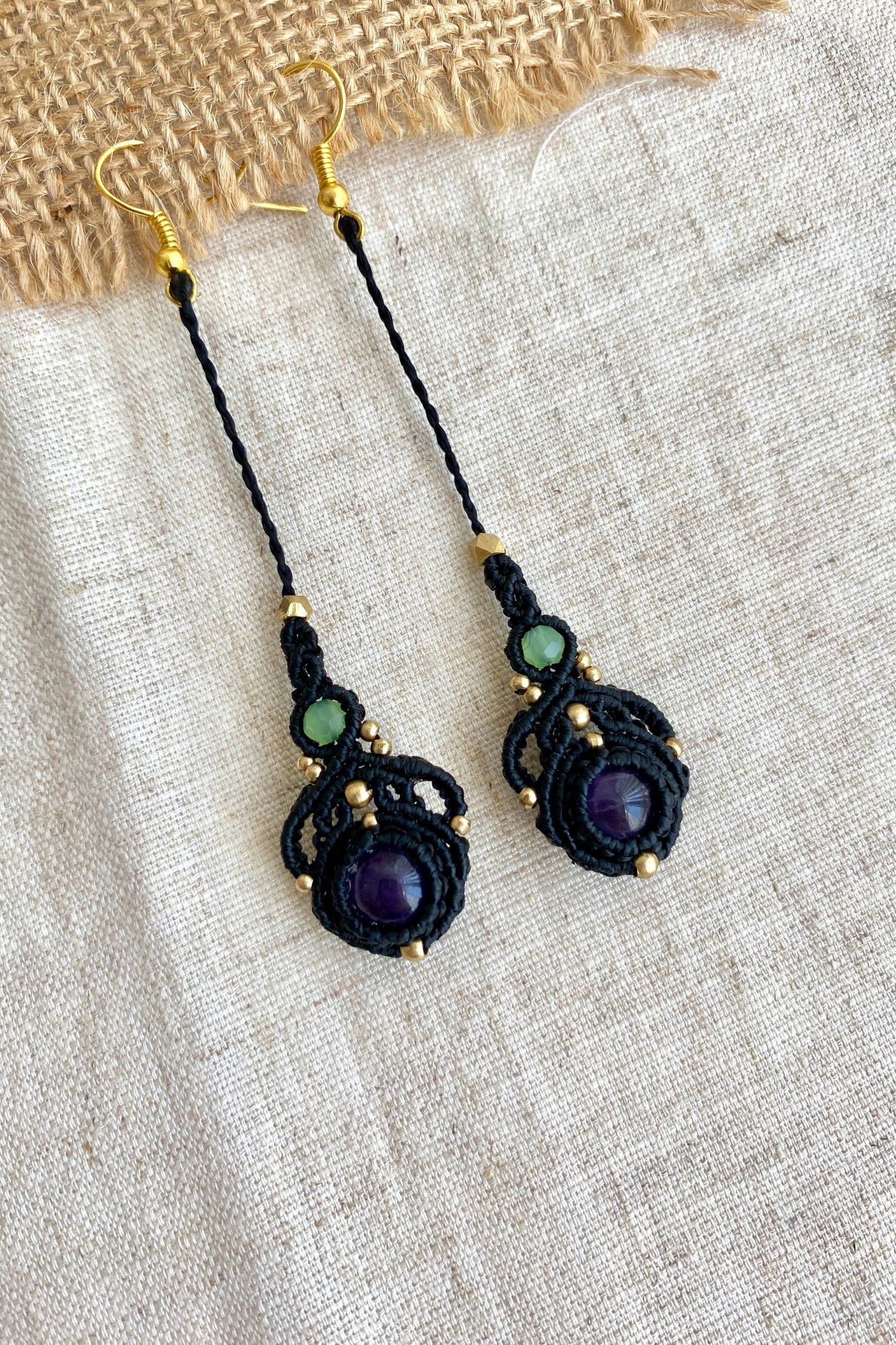 Handmade macrame earrings featuring amethyst and prehnite gemstones, displayed laid flat to showcase the elegant long drop design.