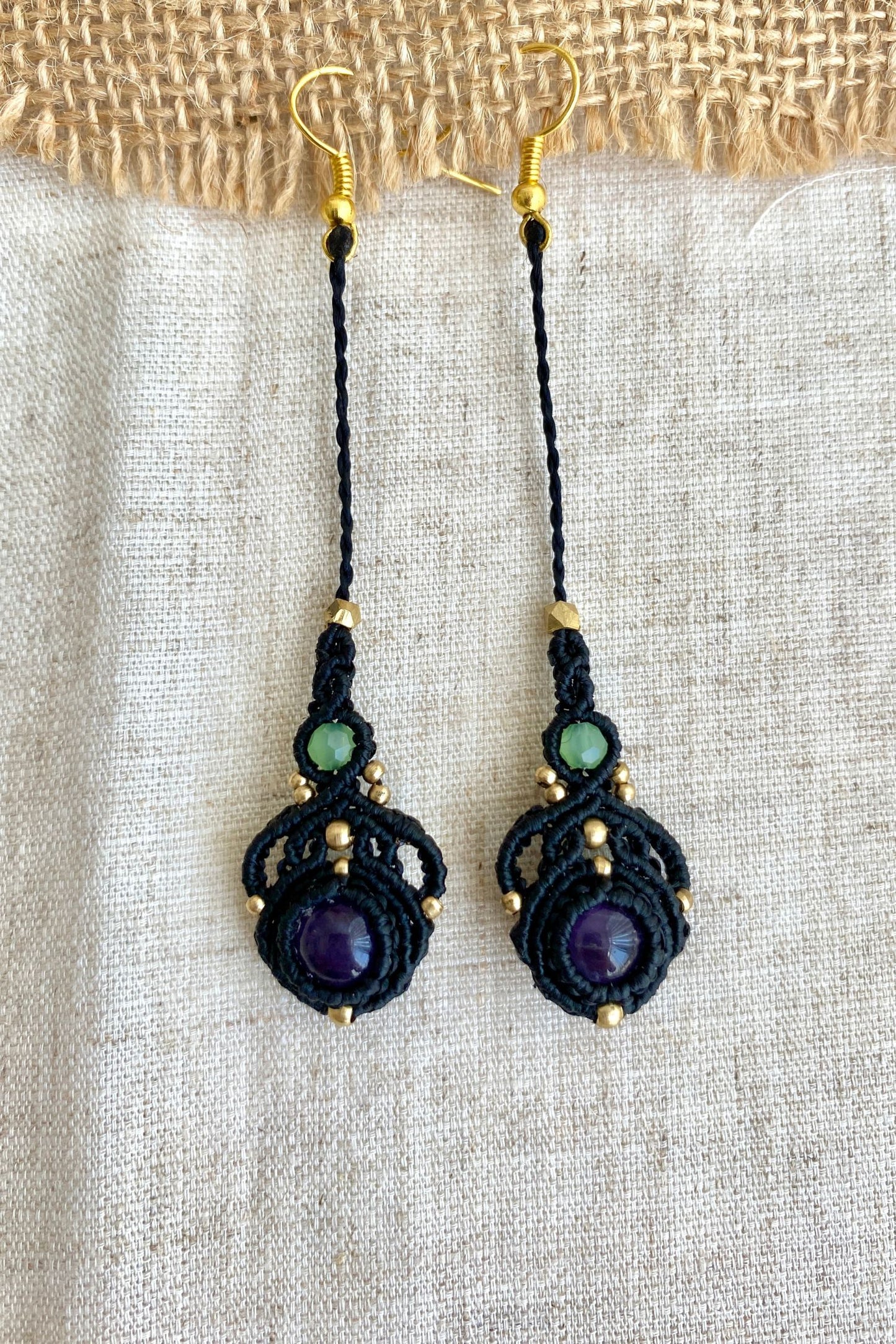 Close-up view of handmade macrame earrings with amethyst and prehnite gemstones, highlighting the intricate knotting and elegant design.
