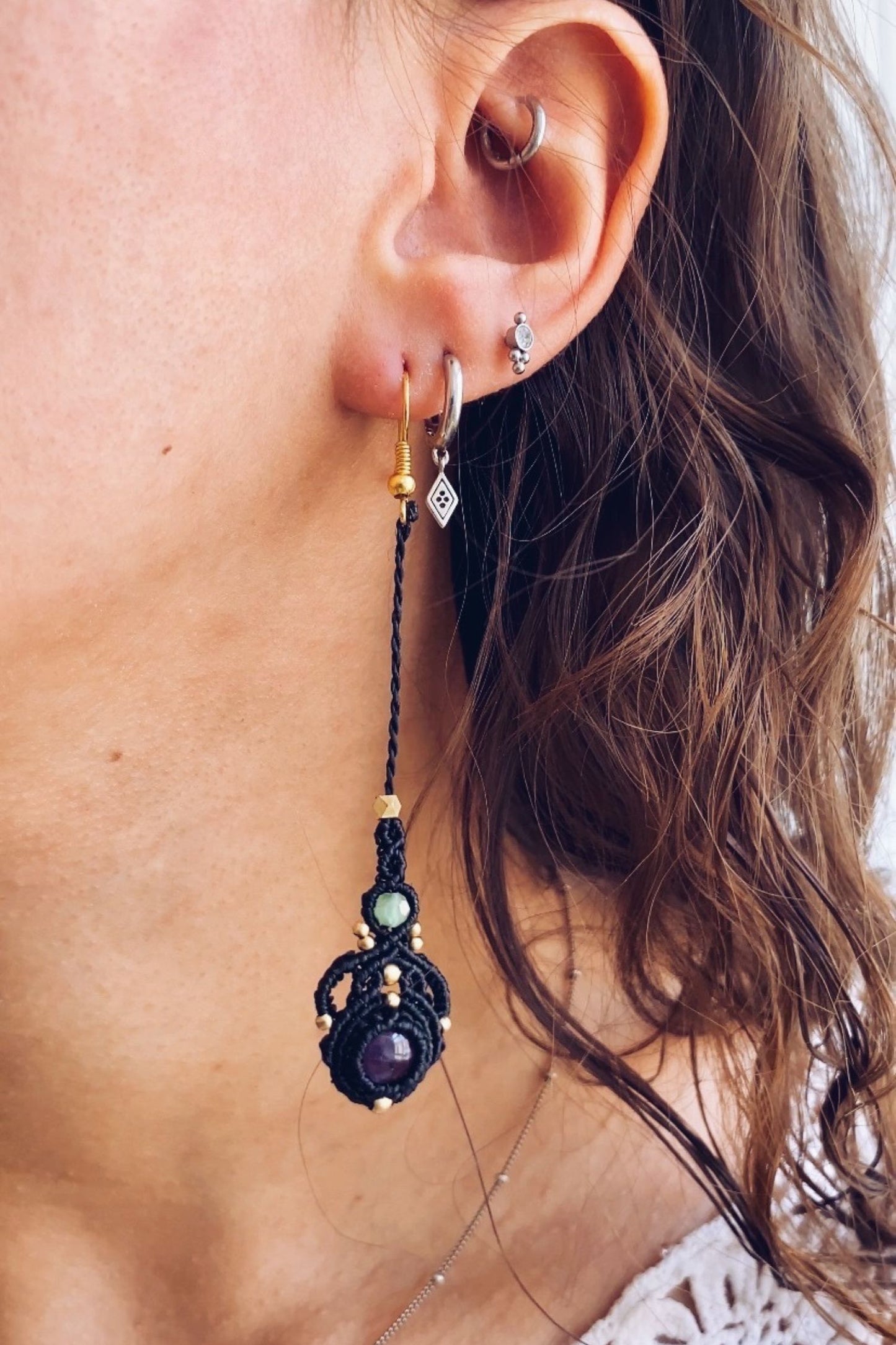 Model wearing handmade macrame earrings featuring amethyst and prehnite gemstones, showcasing the lightweight, long drop style perfect for any occasion.