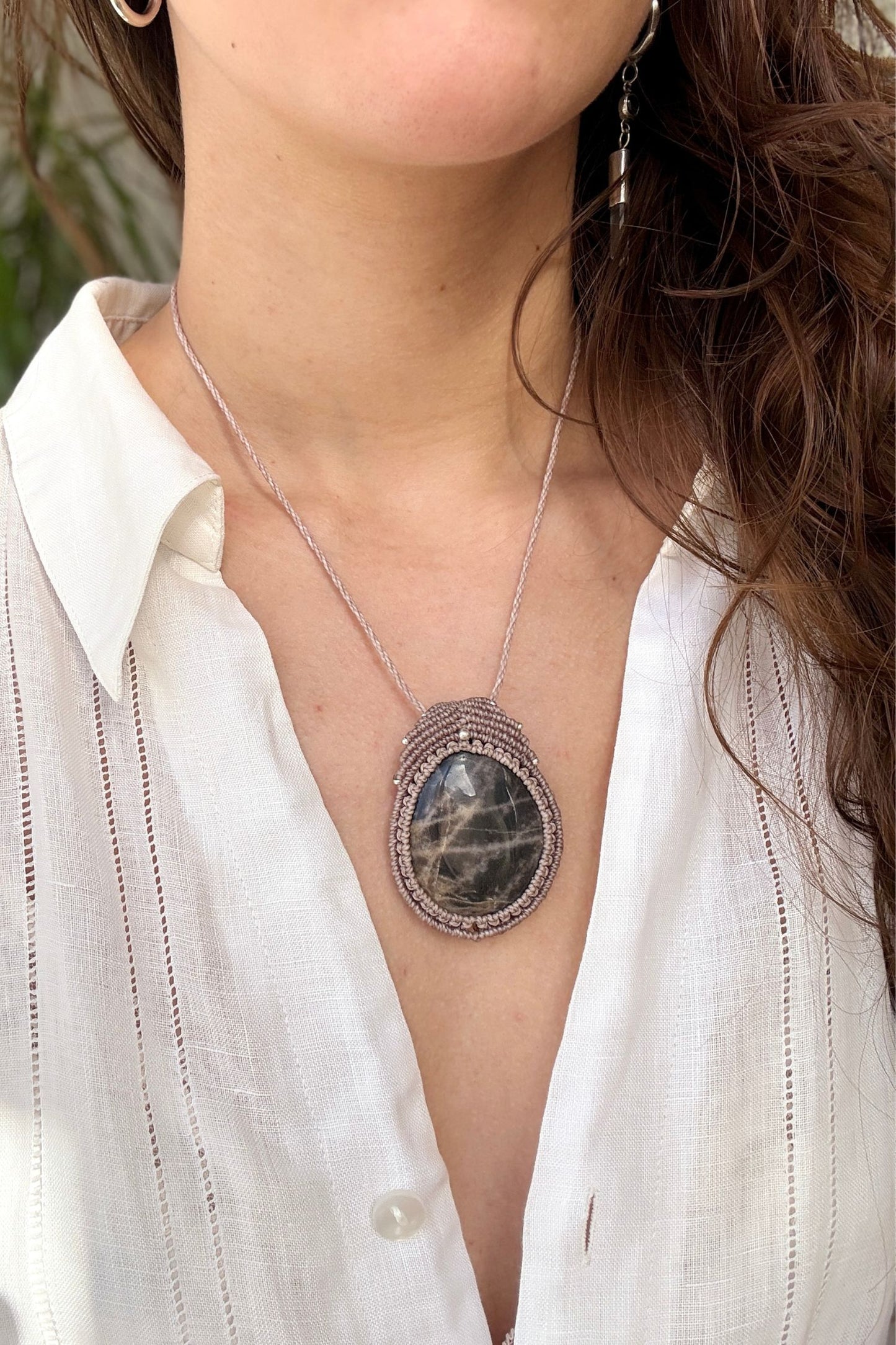 Black Moonstone macrame necklace worn by a model. Showcasing the unique handmade design and how it looks when worn.