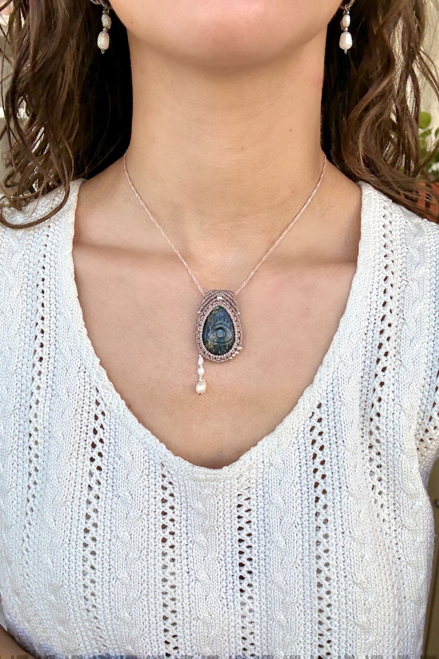 Model wearing handmade Labradorite protective eye necklace, showing how the jewelry rests on the neckline.