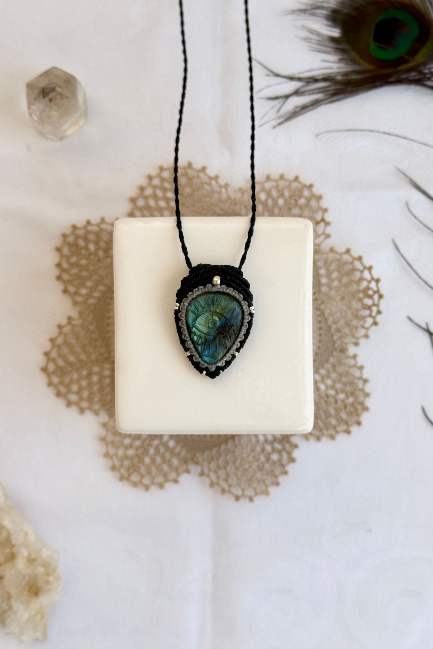 One-of-a-kind Labradorite necklace with carved protective eye, laid flat to highlight its unique shimmer and design.