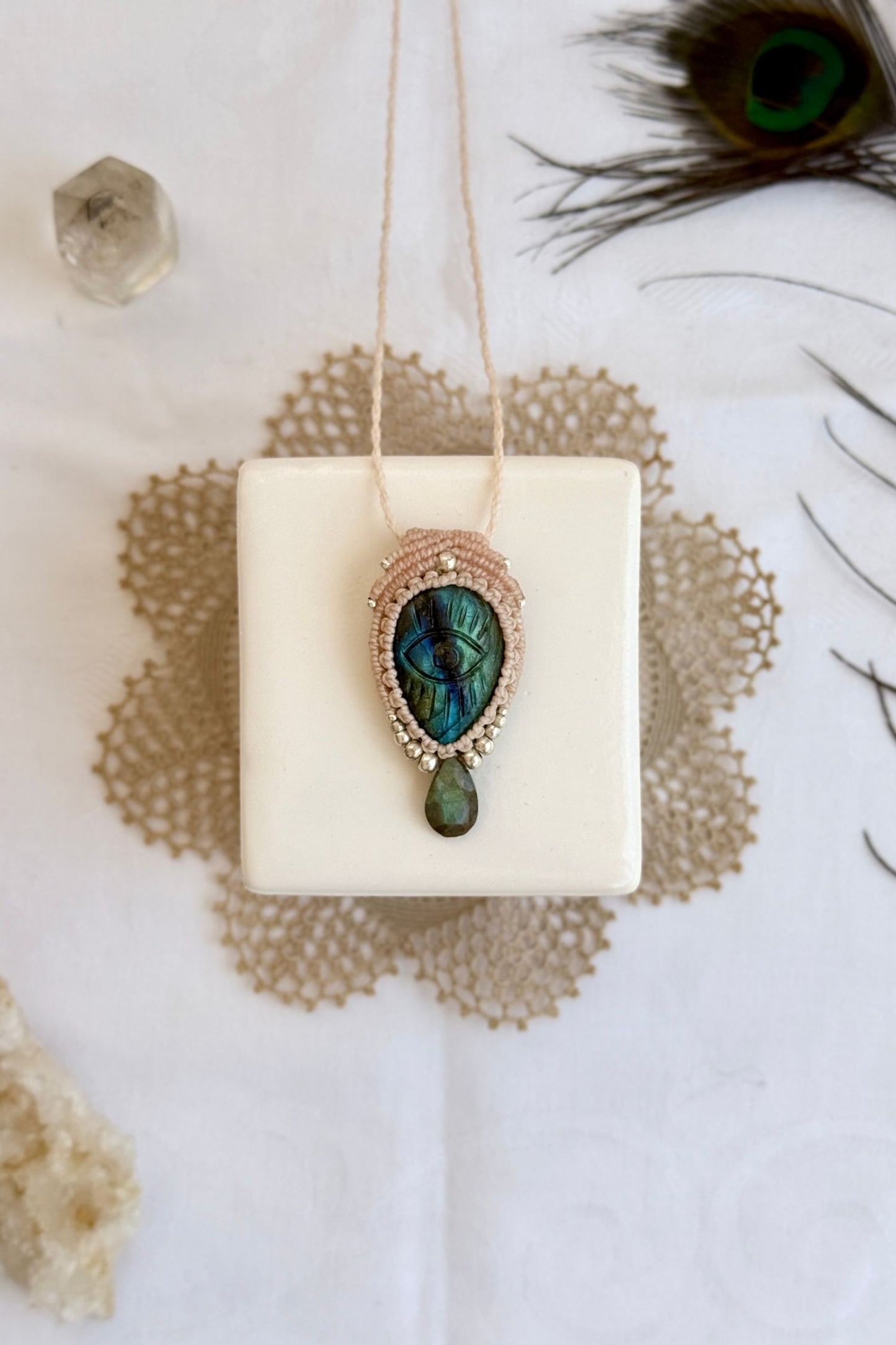 One-of-a-kind Labradorite necklace with carved protective eye, laid flat to highlight its unique shimmer and design.