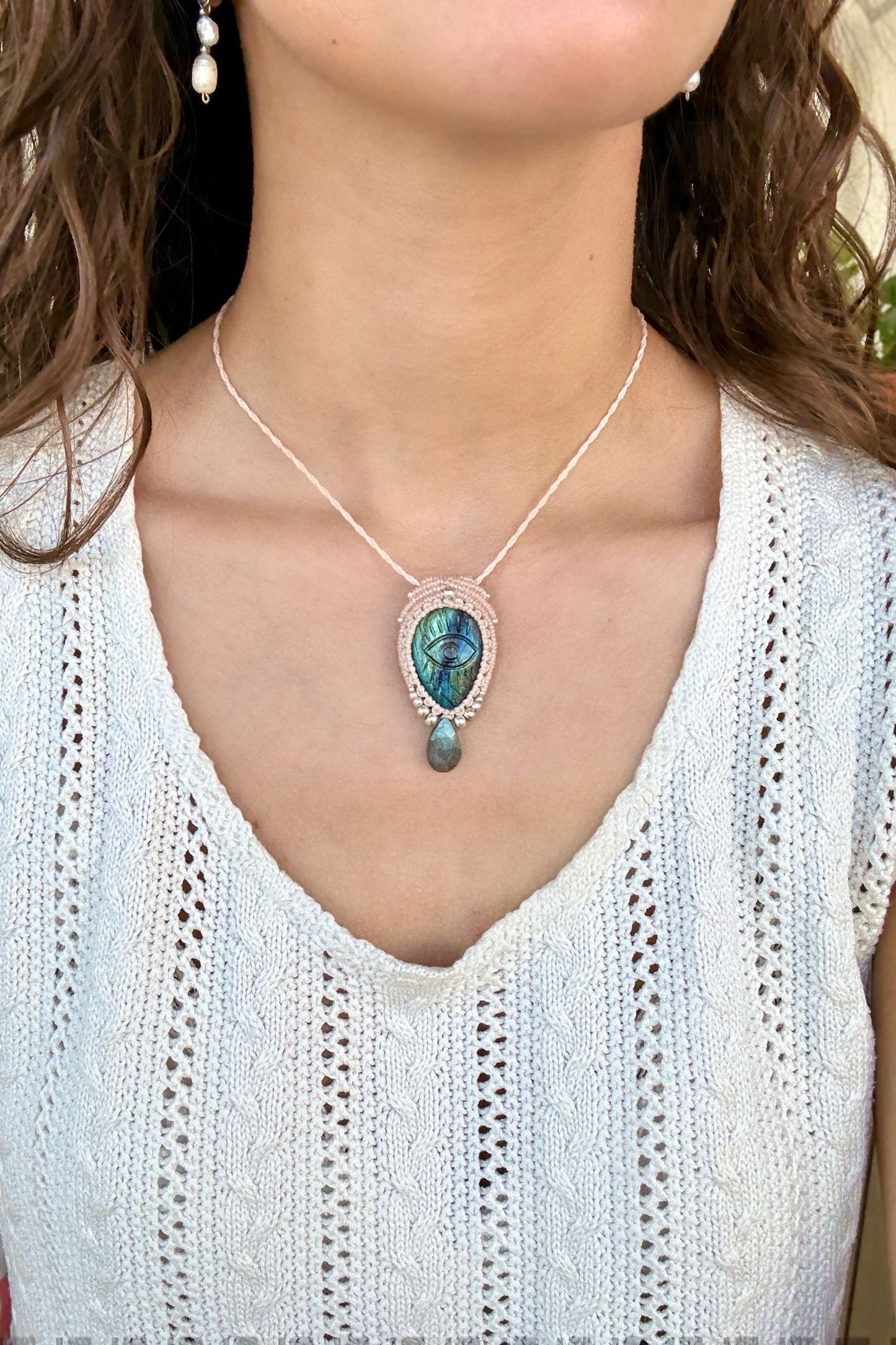 Model wearing handmade Labradorite protective eye necklace, showing how the jewelry rests on the neckline.