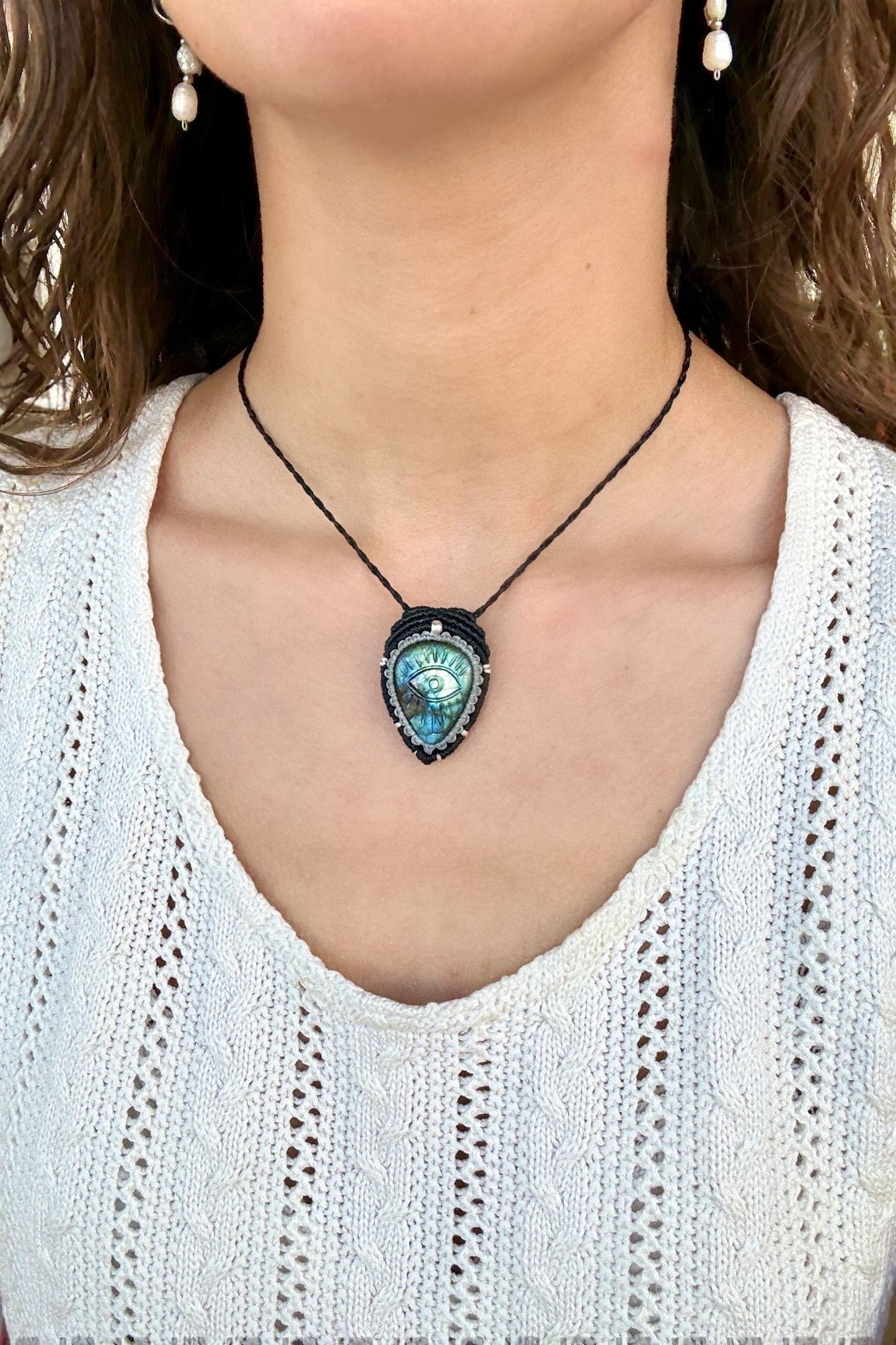 Model wearing handmade Labradorite protective eye necklace, showing how the jewelry rests on the neckline.