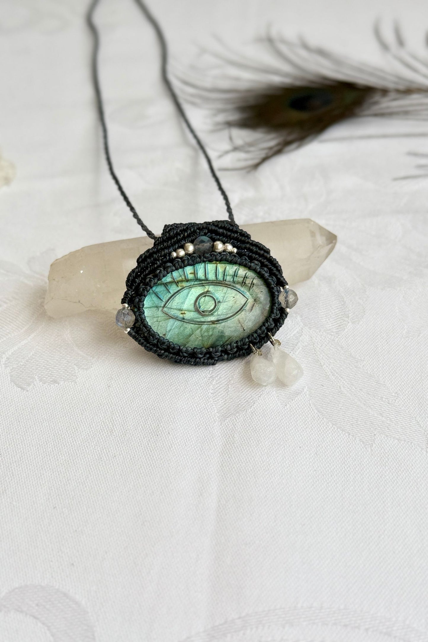 Artisan Labradorite protective eye necklace, shown from another angle to capture gemstone hues and macrame thread work.