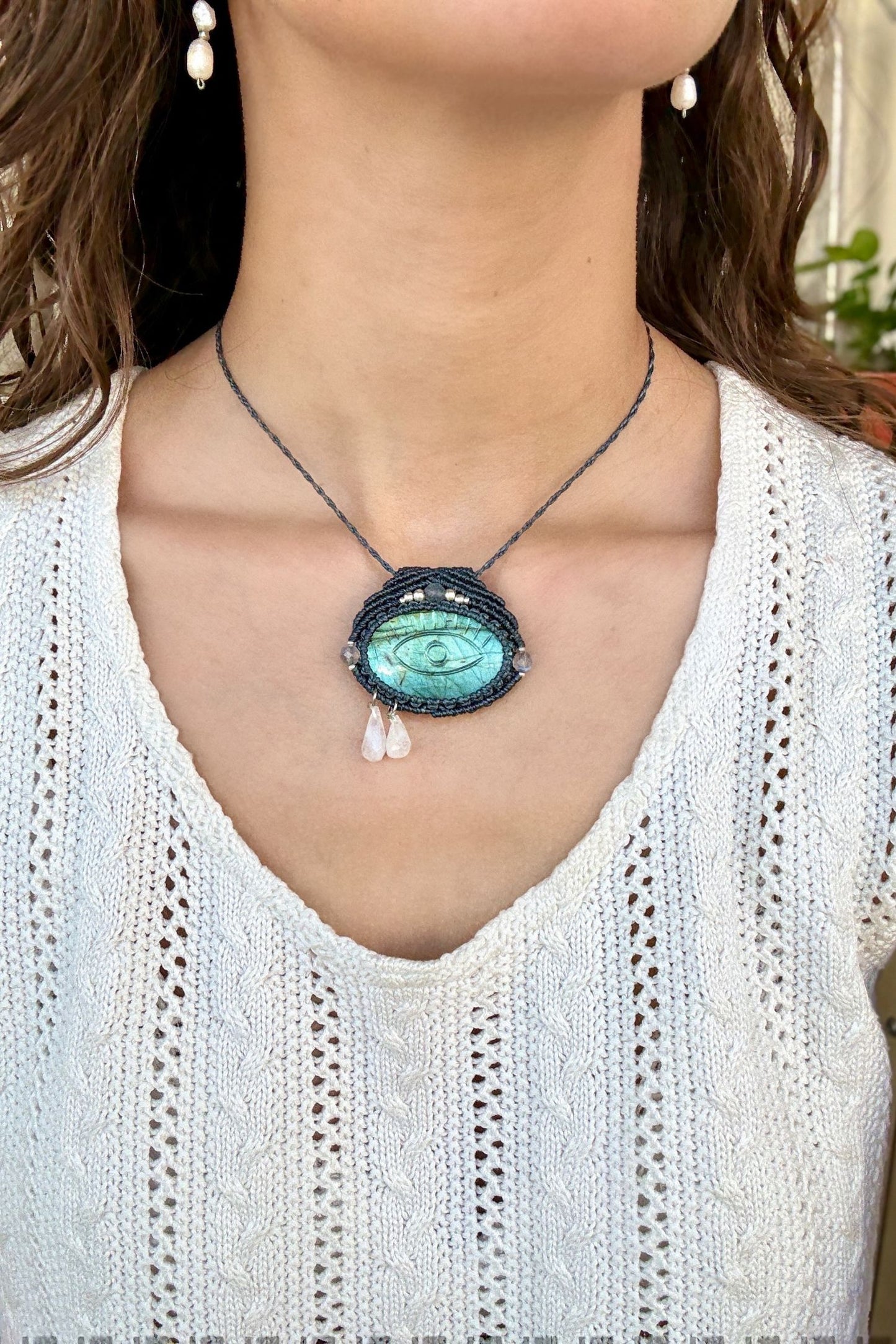 Model wearing handmade Labradorite protective eye necklace, showing how the jewelry rests on the neckline.