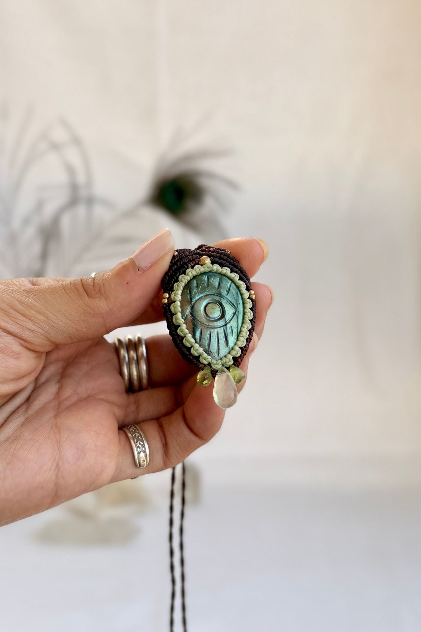 Hand holding handmade Labradorite macrame necklace with drops of Epidote and Prehnite gemstones, showing the scale and carved details