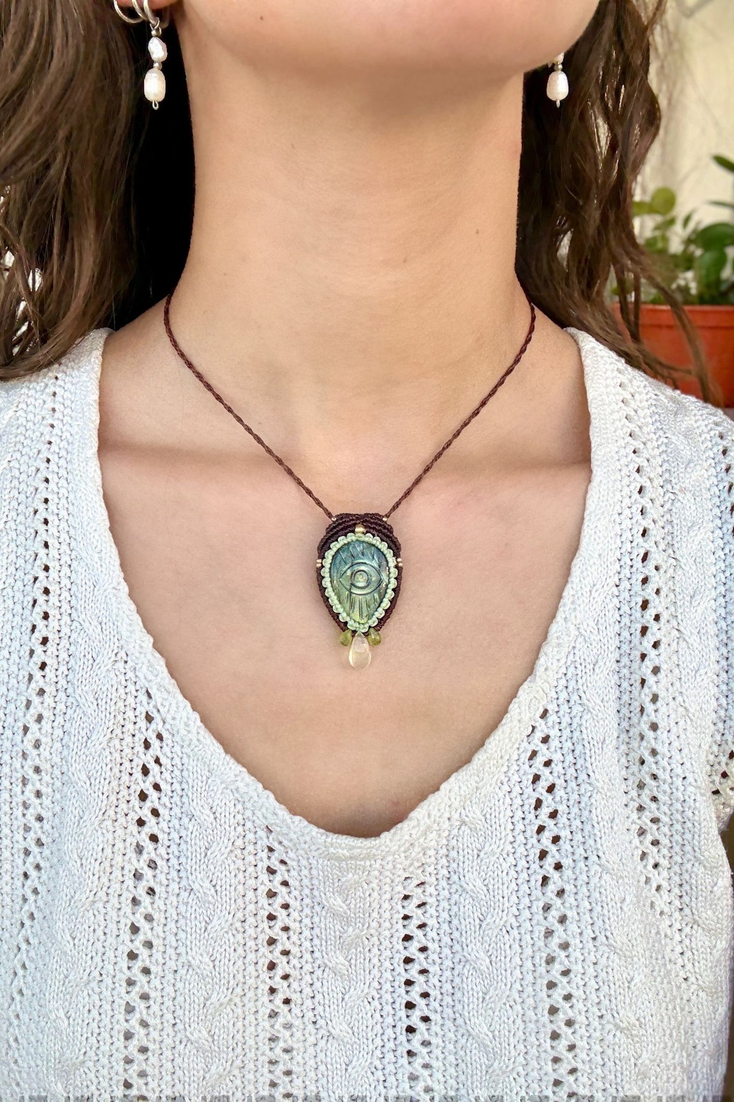 Model wearing handmade Labradorite protective eye necklace, showing how the jewelry rests on the neckline.